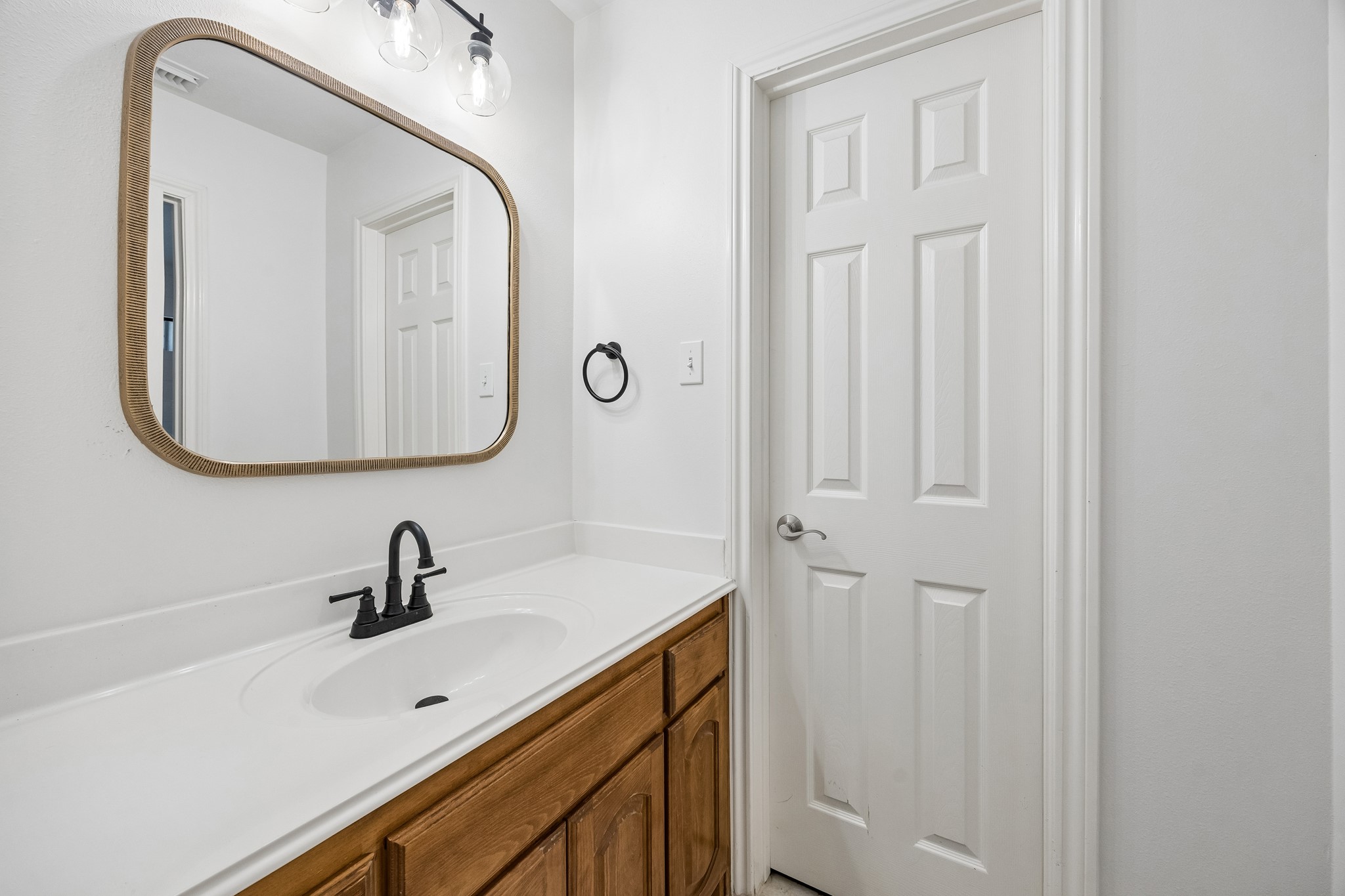 Convenient Jack-and-Jill bath connects two secondary bedrooms, with a private vanity area offering generous counter space, updated fixtures, and a neutral design that provides added function and privacy for family or guests.