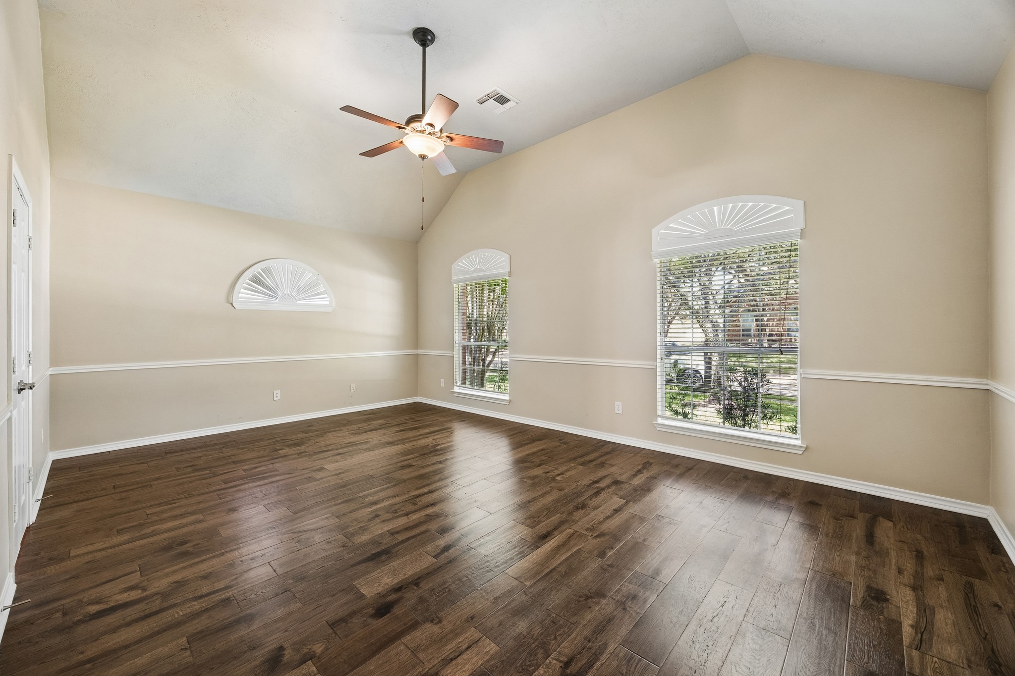 Spacious primary suite features engineered hardwood flooring, high ceilings, elegant trim detail, and large windows providing abundant natural light. Generous proportions offer plenty of flexibility for furniture and a private seating area.