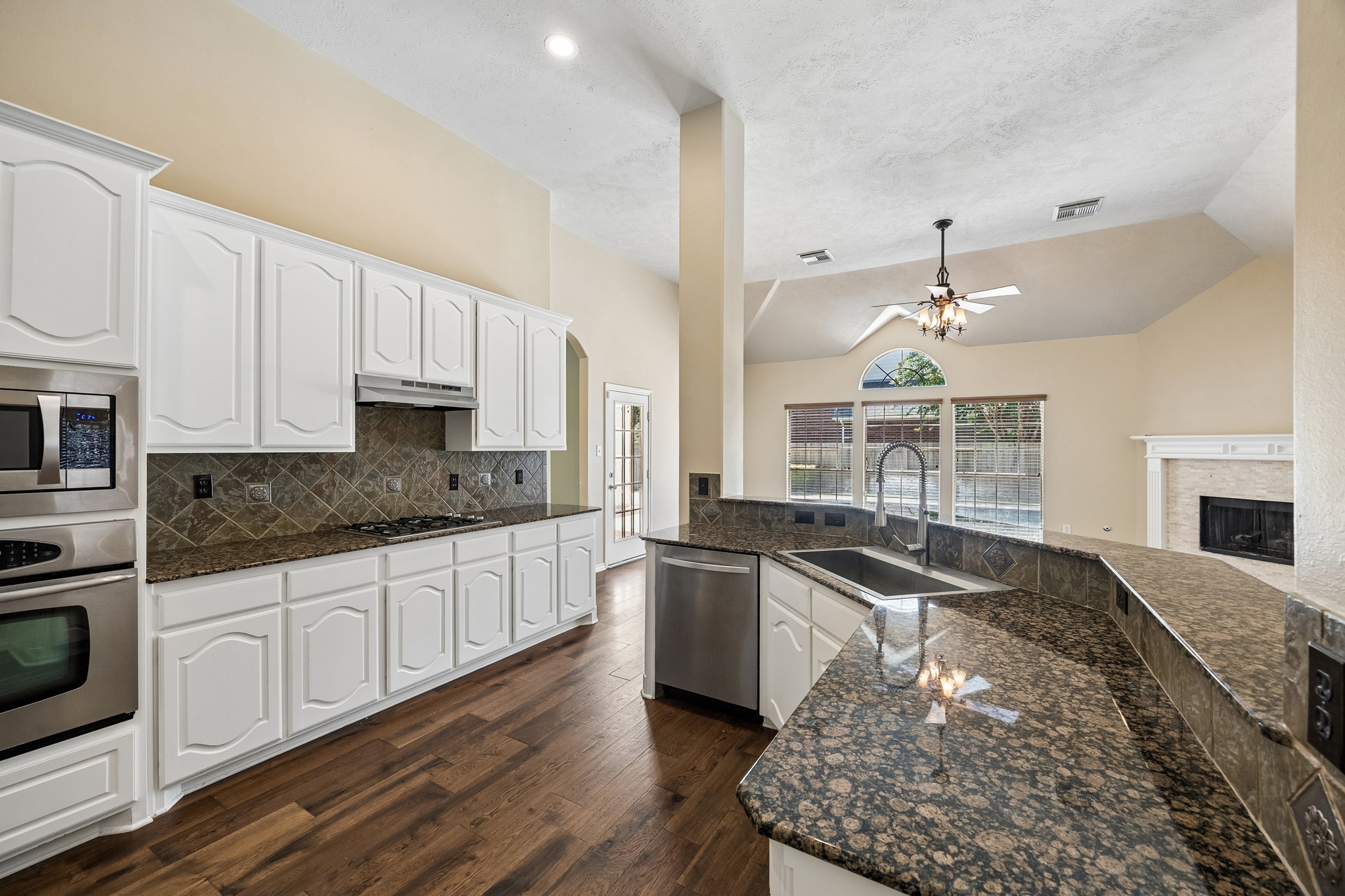 Designed with both function and style in mind, the kitchen offers expansive granite countertops, abundant cabinetry, stainless steel appliances, and a spacious breakfast bar perfect for casual dining, meal prep, or entertaining.