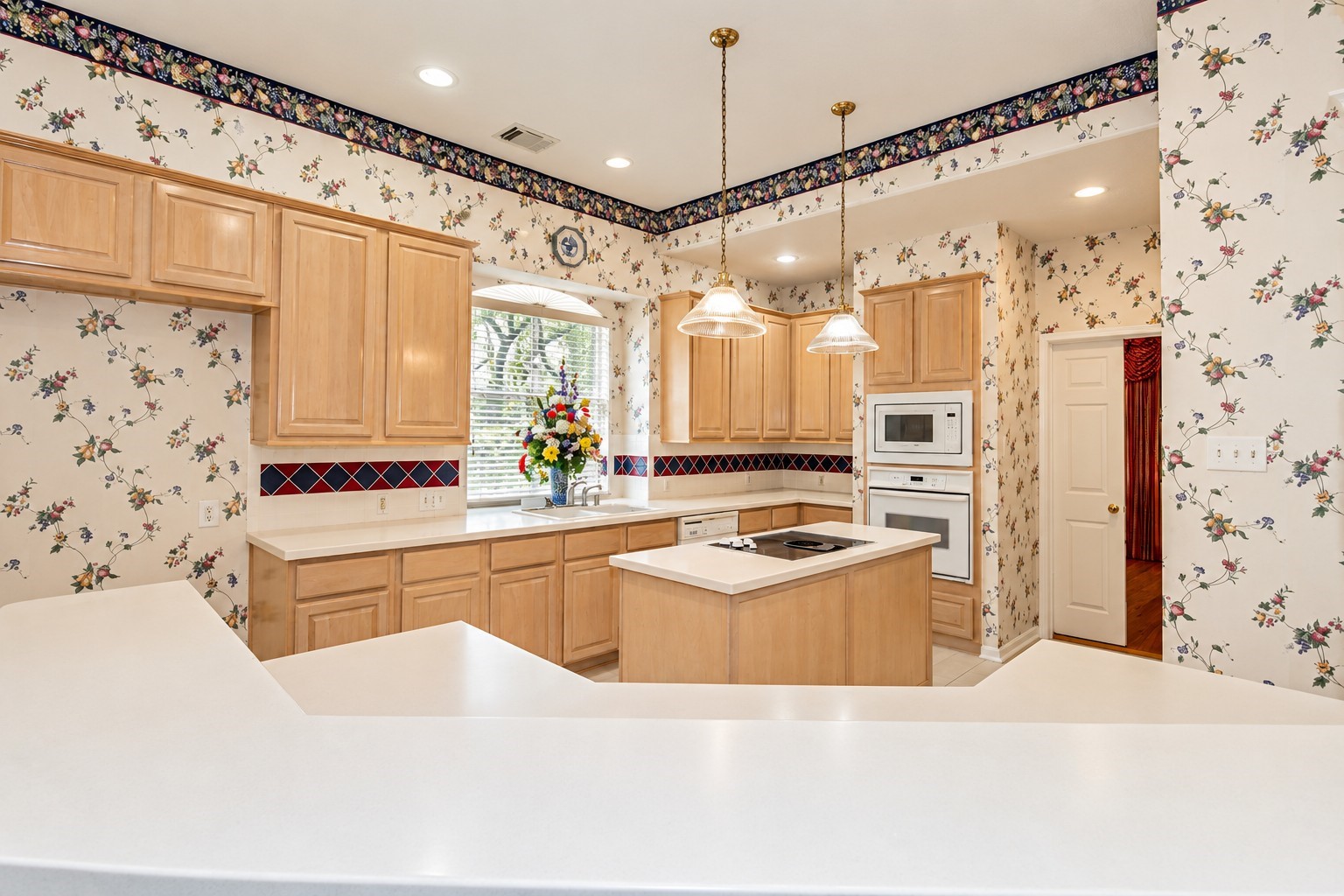 View from breakfast bar of the large island kitchen with lots of cabinets