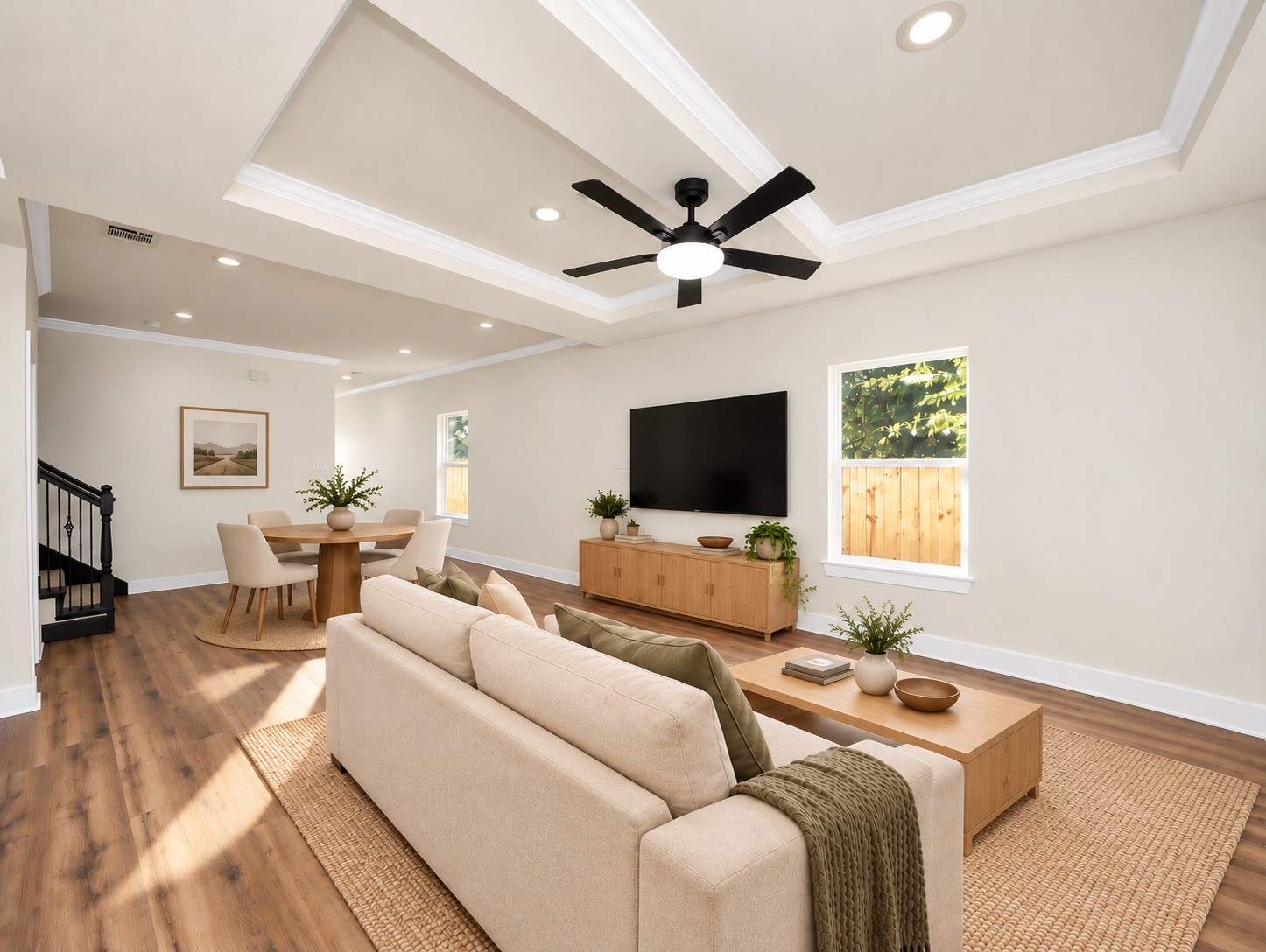 Additional view of the main living space highlighting the home's open layout, recessed lighting, elegant ceiling details & dedicated dining area | Virtually staged