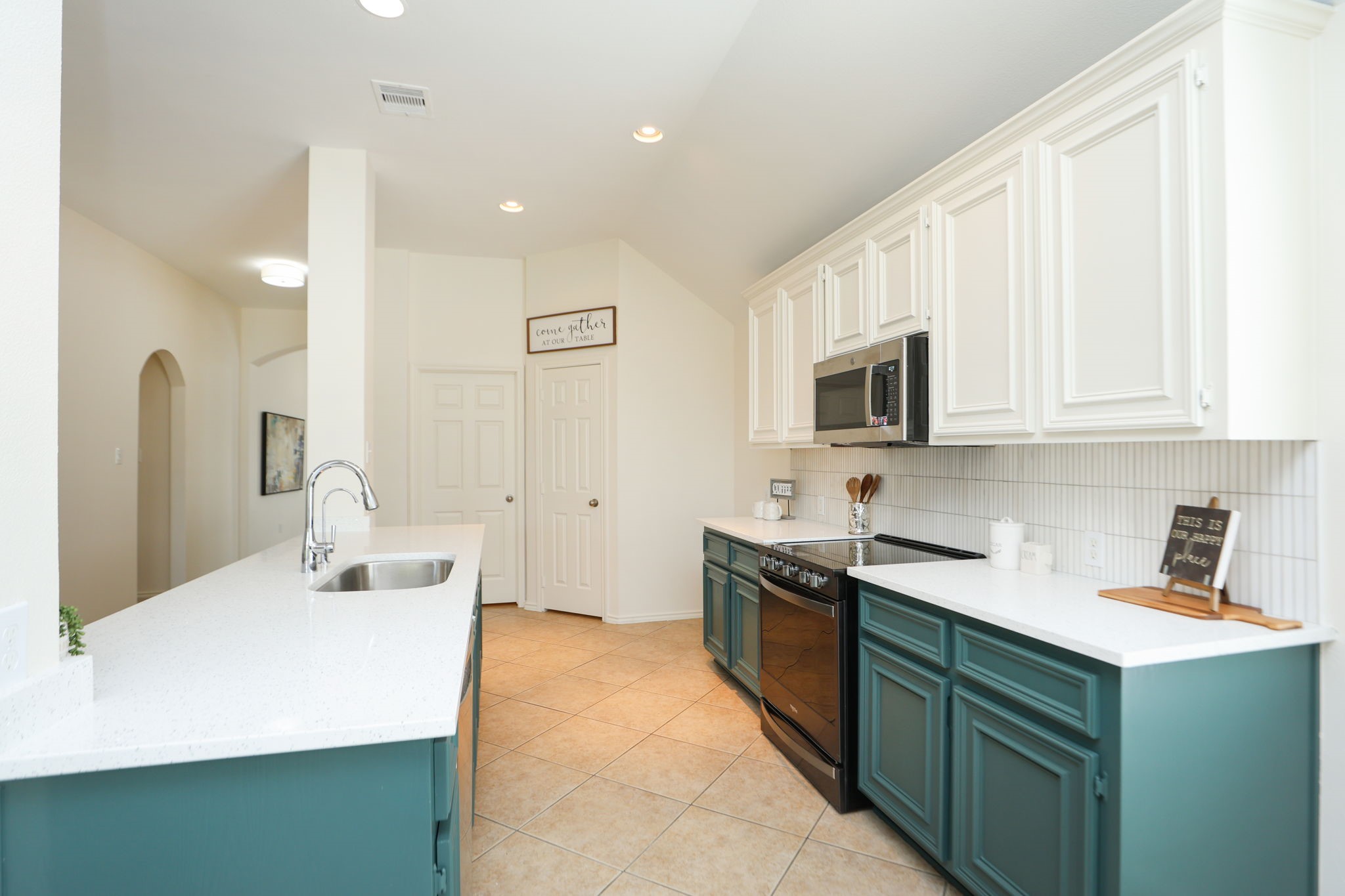 Room for bar stools at this large island for friends and family to gather around. Pantry and laundry room in back of photo with hallway to secondary bedrooms on the left of this photo. Split floorplan is very peaceful and gives privacy to the primary suite in the rear.