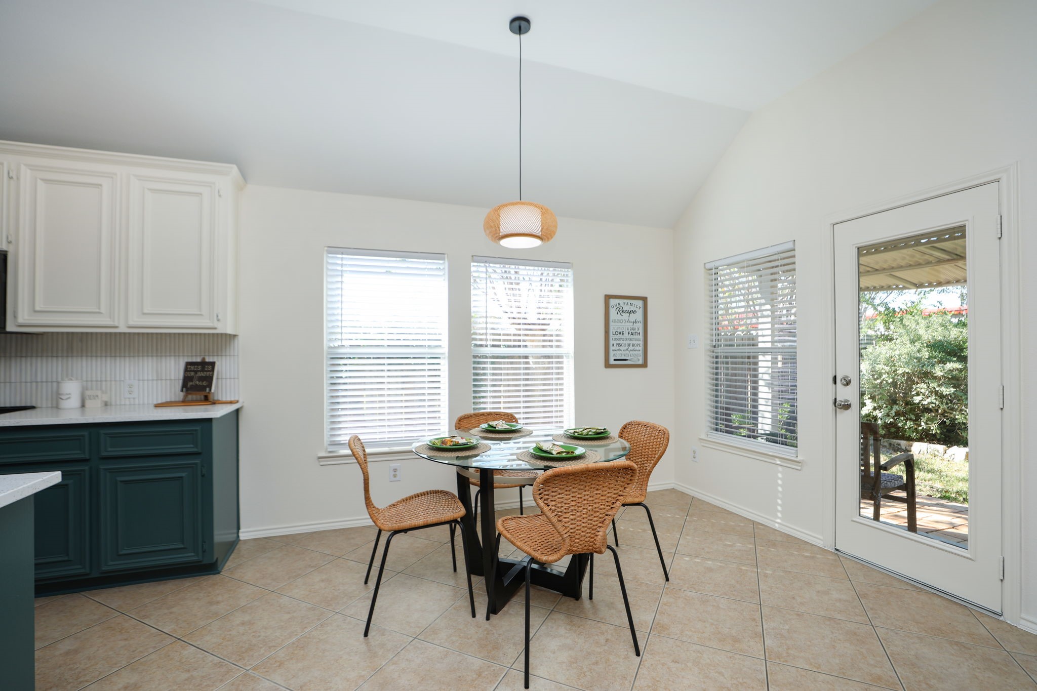 Large eat-in kitchen with windows to the lush backyard. Back door and porch to the right of this photo.
