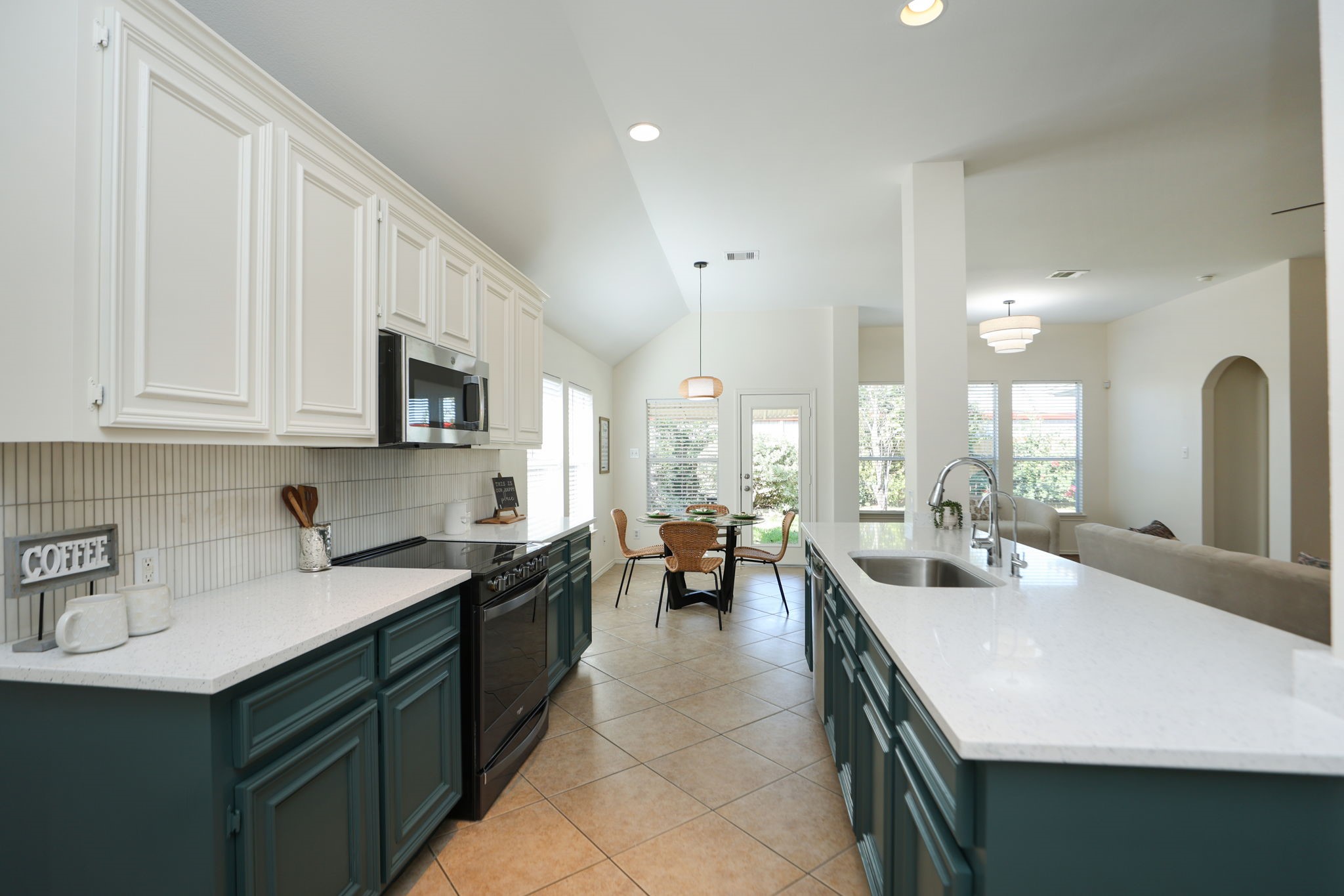 Kitchen features duo-toned cabinets, new countertops and vertical channel set backsplash!