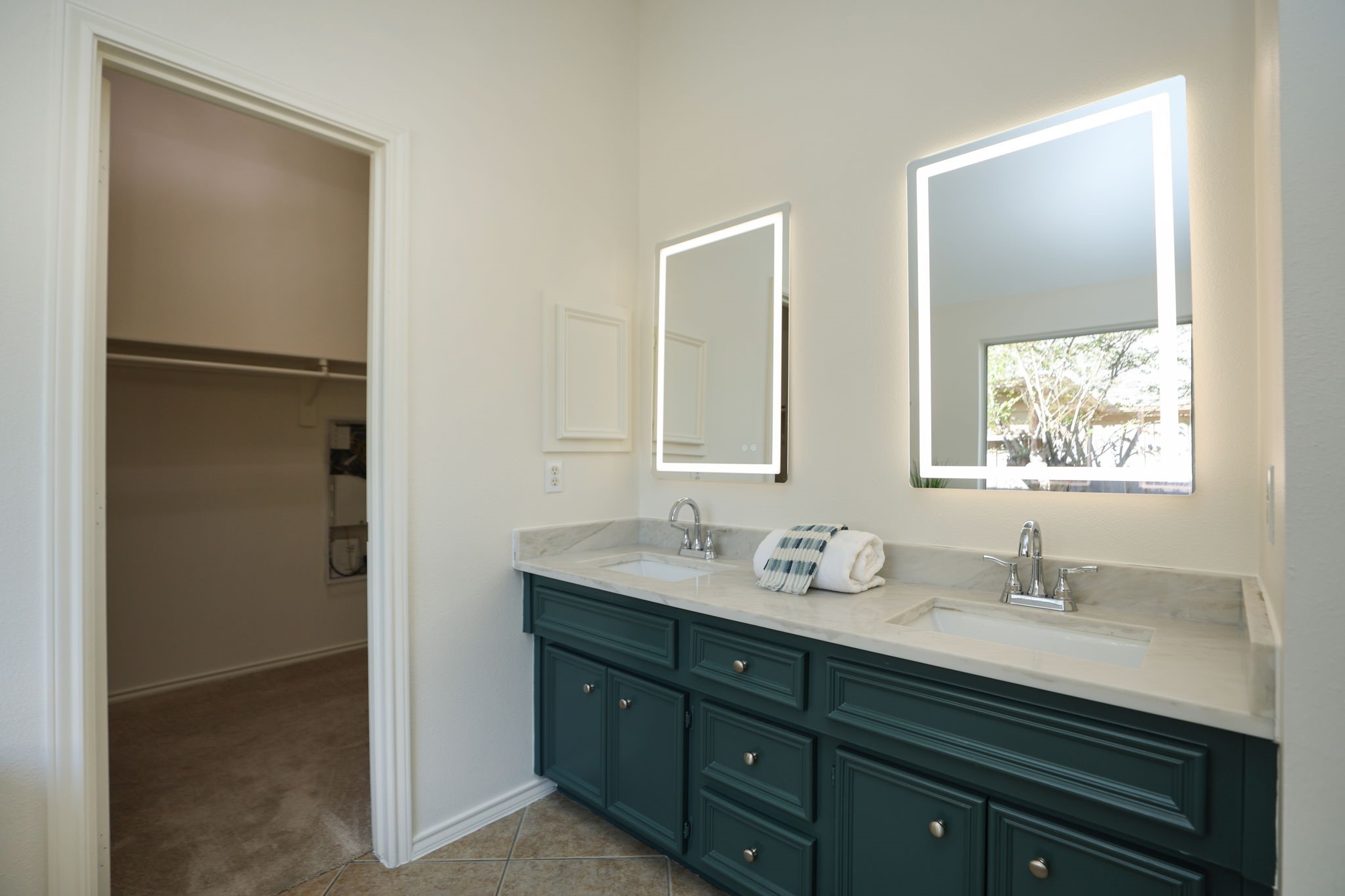 Primary bath features a light countertop and optional lit vanity mirrors. Whole home has been redone for its new owner!