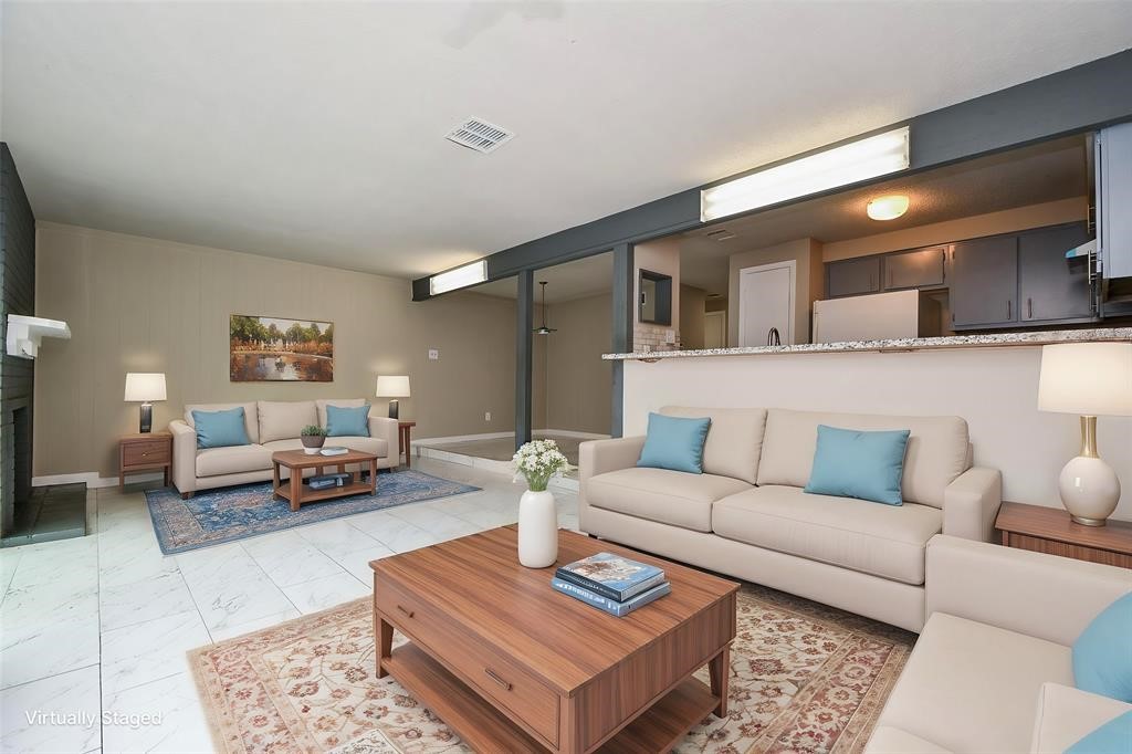 This virtually staged photo showcases a spacious, open-concept living area with modern furnishings and neutral colors. It features a cozy seating arrangement, a fireplace, and a view into the kitchen, creating a warm and inviting atmosphere. Virtual staging was used. This virtually staged photo showcases a spacious, open-concept living area with modern furnishings and neutral colors. It features a cozy seating arrangement, a fireplace, and a view into the kitchen, creating a warm and inviting atmosphere. Virtual staging was used.
