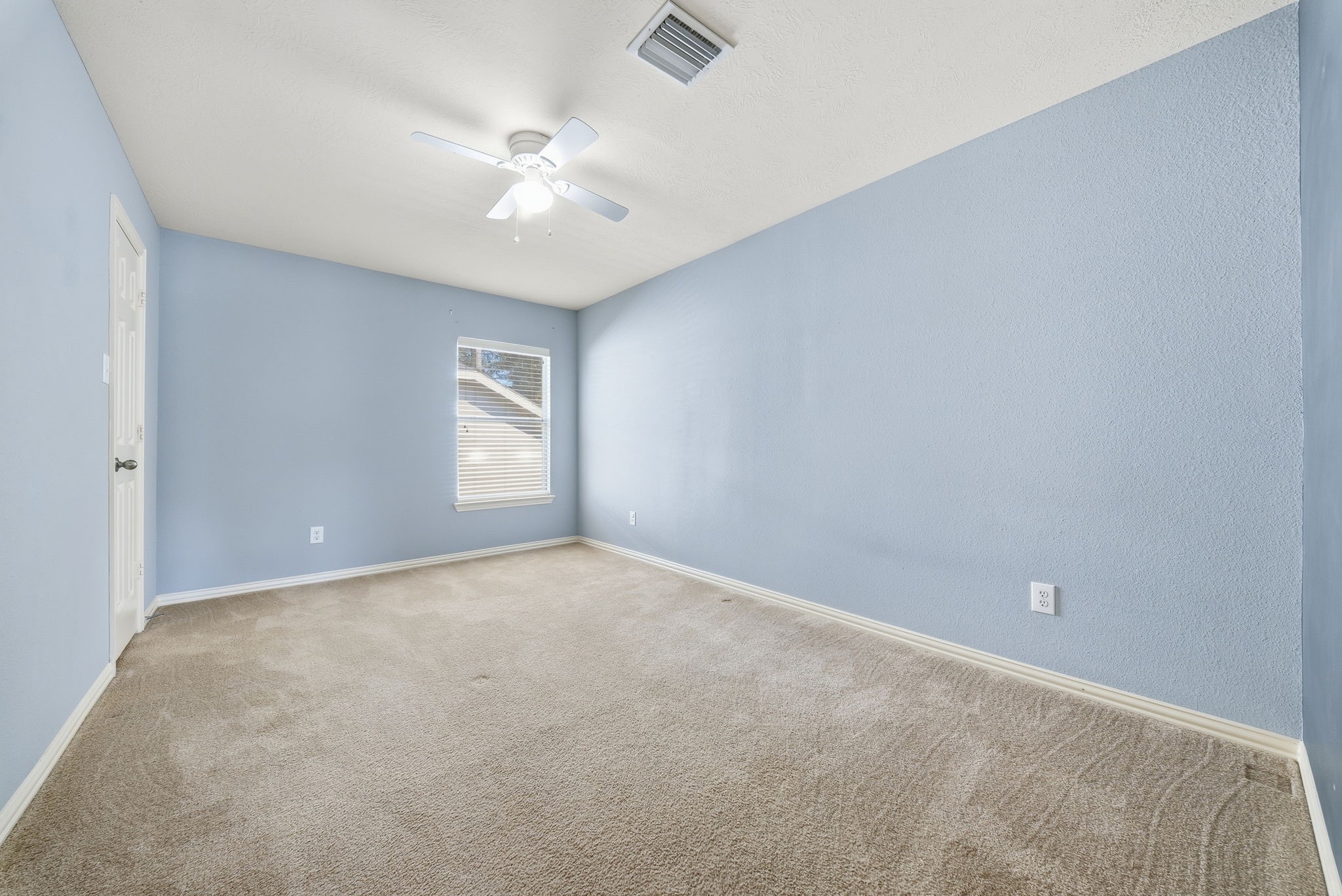 Bedroom 3 located upstairs, offers ample room for a bed, dresser, and study space, with natural light and a ceiling fan for added comfort.