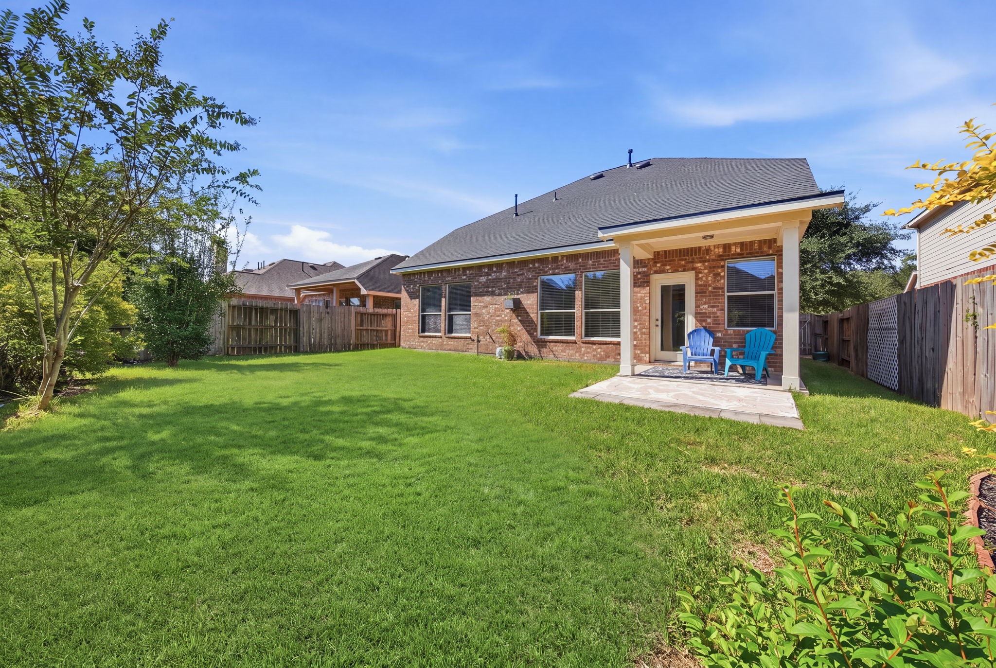 Enjoy outdoor living with a covered patio, established trees, and a spacious fenced lawn offering room for pets, play, and weekend gatherings.