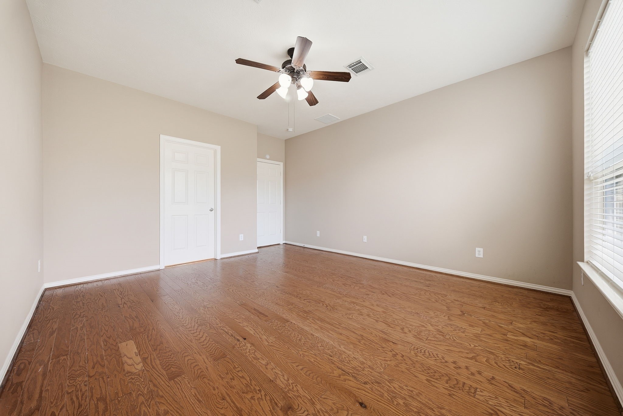 Your downstairs primary retreat features direct access to the private bathroom on the left, with the doorway on the right leading back to the homes main living areas.