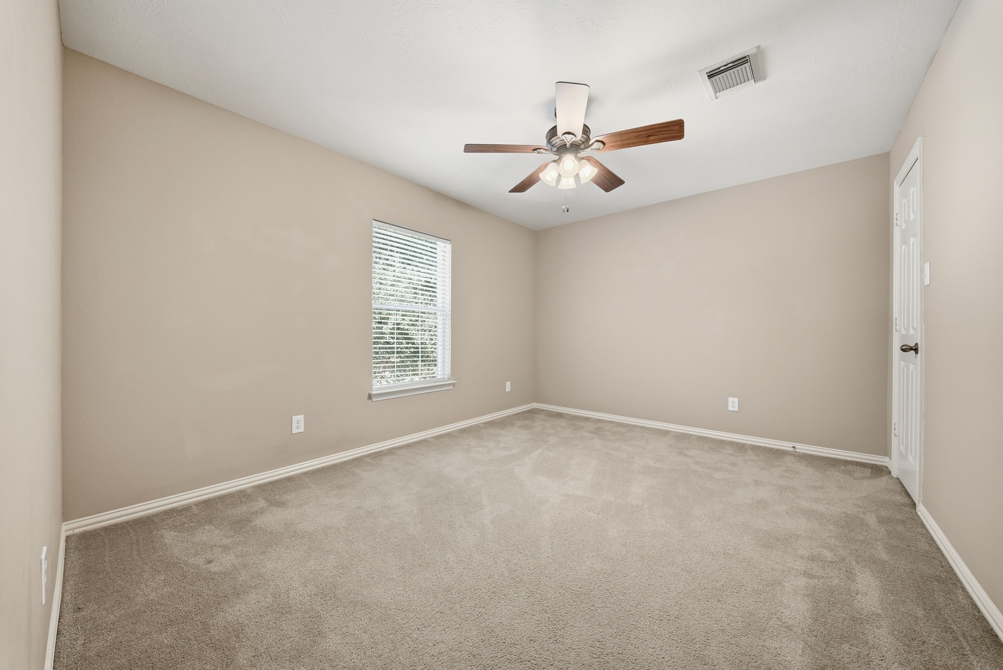 Bedroom 2, located upstairs to the left of the stair landing, features a window overlooking the front of the home that brings in natural light.