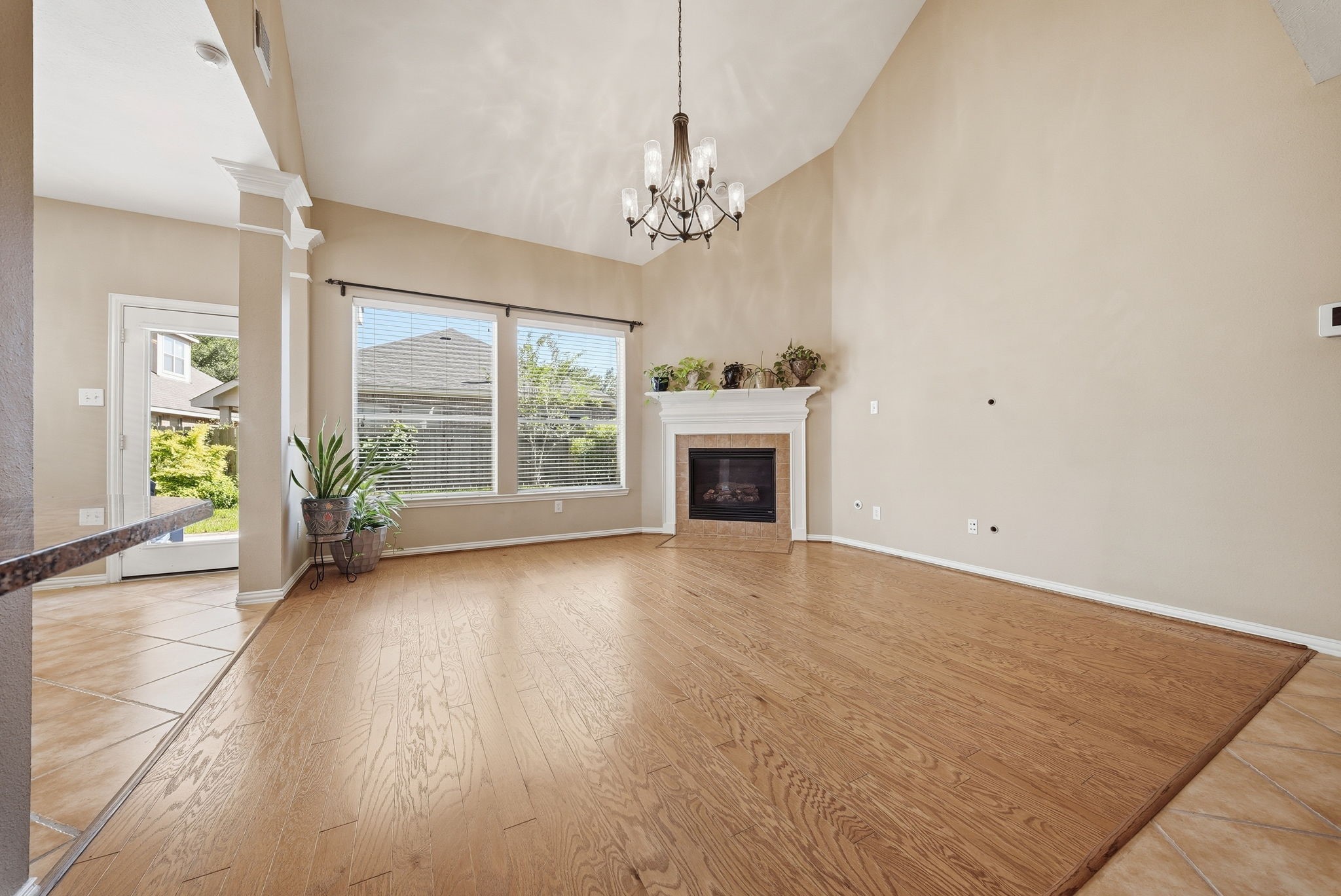 Soaring ceilings, large windows, and a corner fireplace create a bright, inviting living area with plenty of room to relax or entertain.