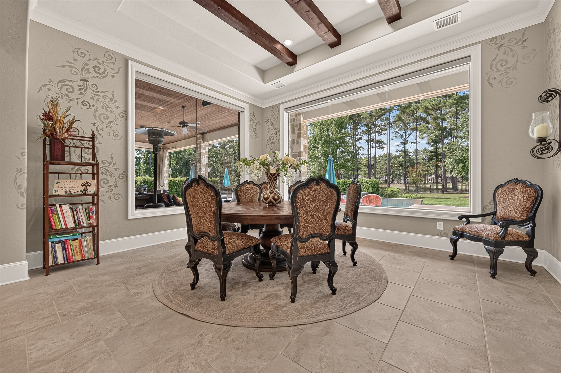Dining room with oversized windows over looking covered patio and pool. Dining room with oversized windows over looking covered patio and pool.