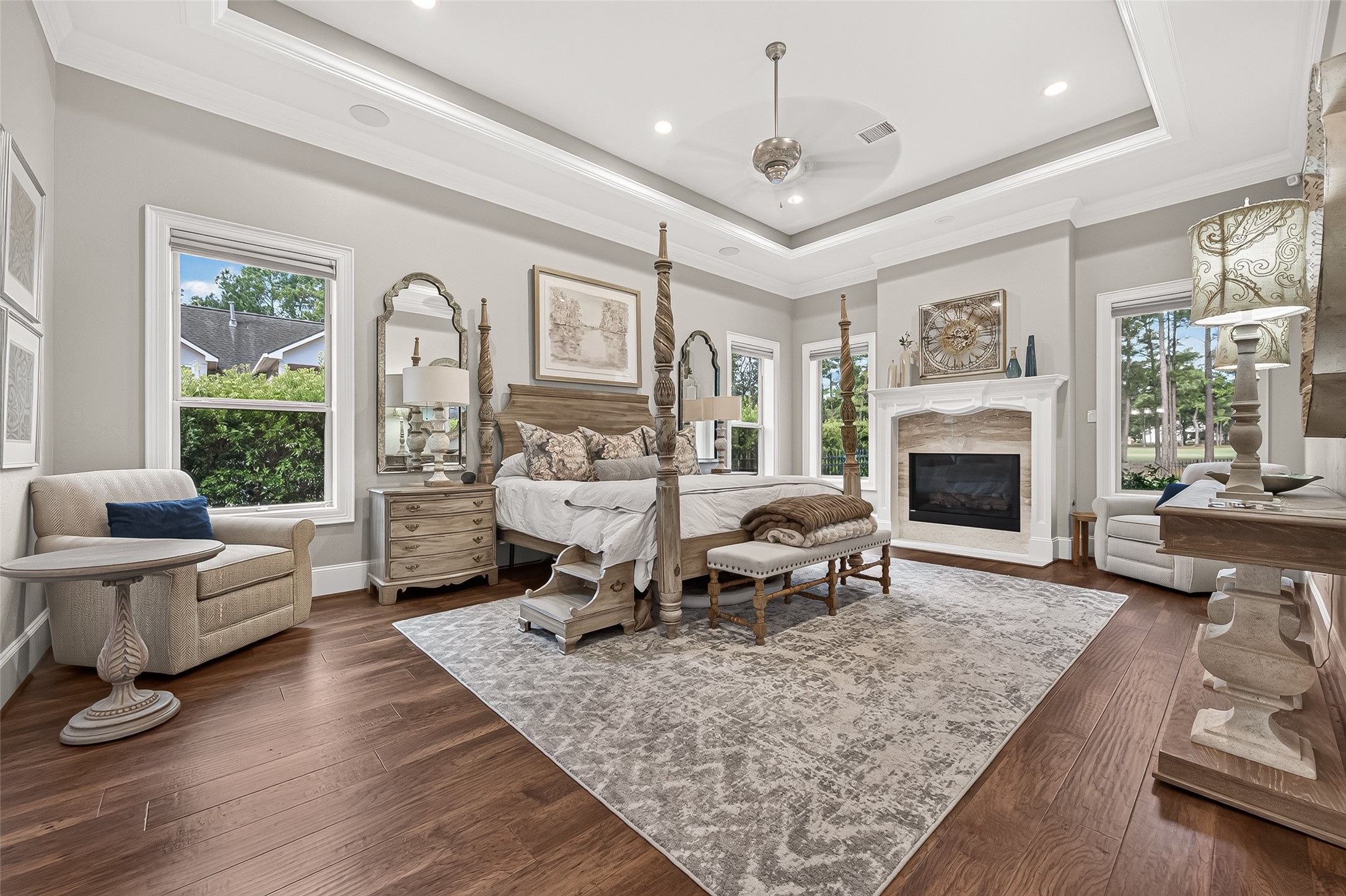 Primary suite with a tray ceiling, wood floors and it's own fireplace.