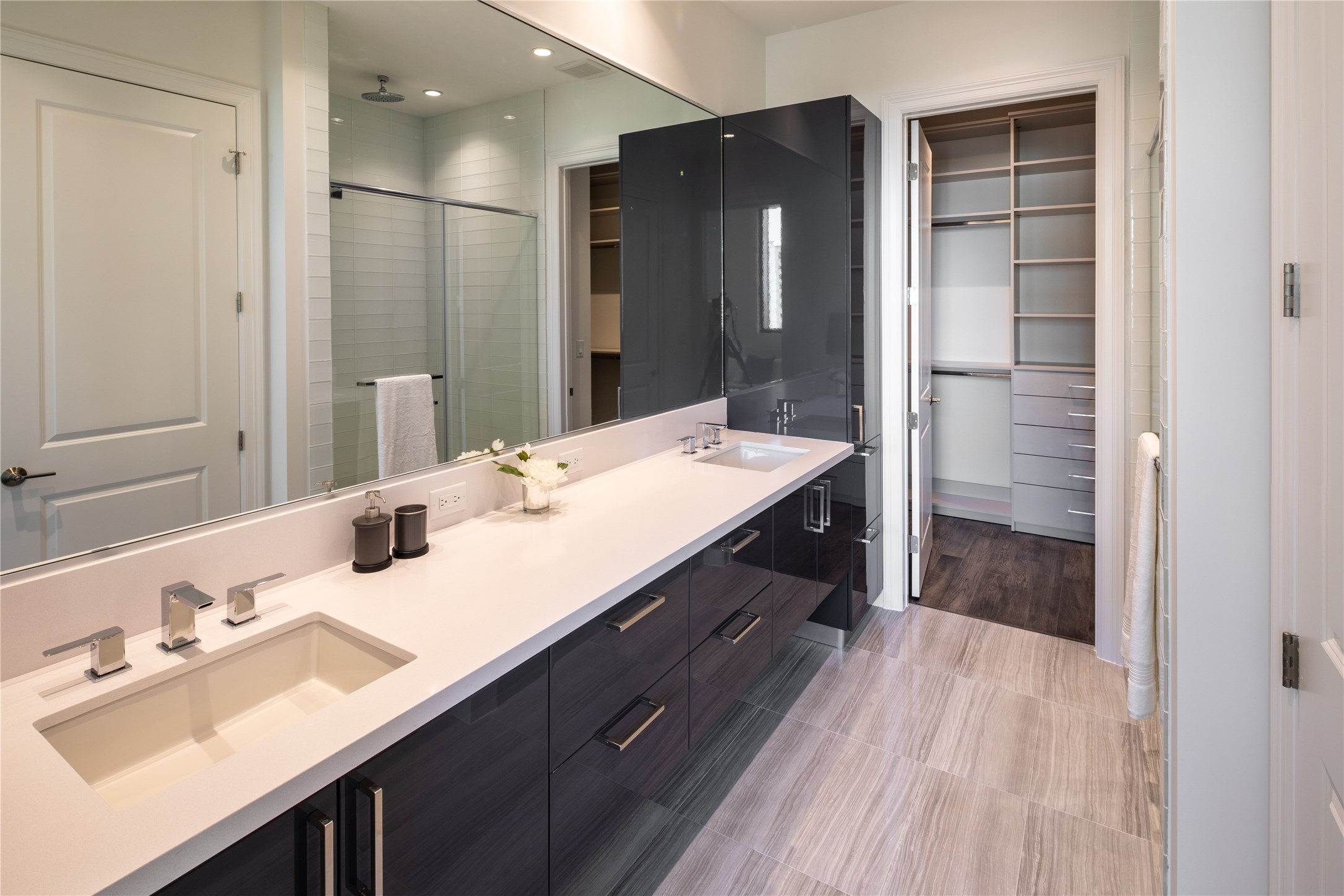 [Primary Bath] Elegant Primary bath with oversized shower, double sinks,  quartz countertops, and handsome lacquered Pedini cabinetry... including a linen cabinet