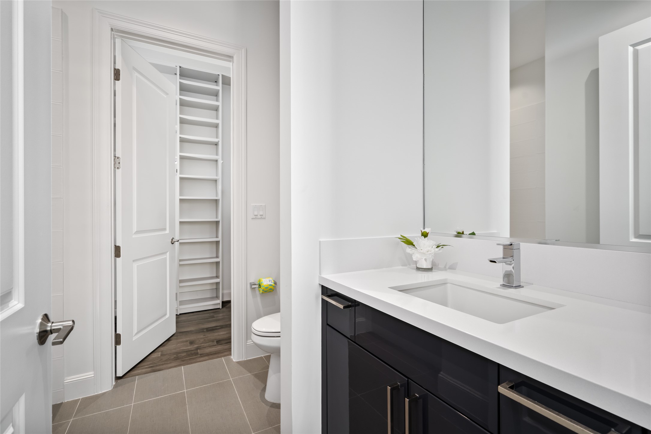 [Secondary Full Bath & Closet] Handsome bathroom with tub/shower combo, boasting elegant quartz counters, classic chrome fixtures, lacquered Pedini vanity and  large custom closet
