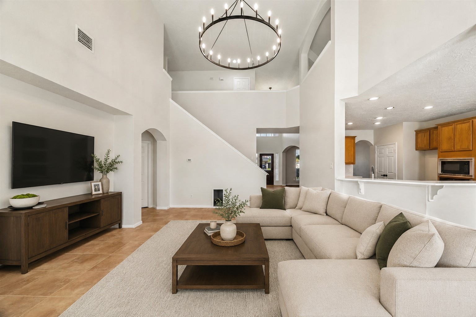 DRAMATIC TWO-STORY LIVING AREA WITH SOARING CEILINGS, AN OVERSIZED STATEMENT LIGHT FIXTURE, AND AN OPEN-CONCEPT CONNECTION TO THE KITCHEN. *Virtually staged. *Virtually staged.