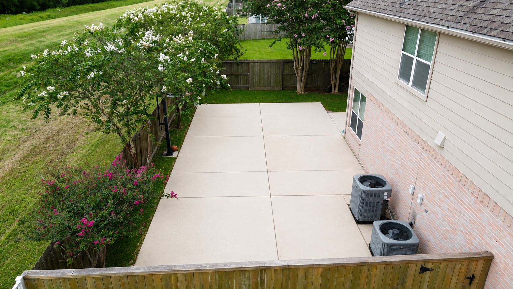 EXPANSIVE BACKYARD FEATURES A LARGE CONCRETE PATIO/SPORT AREA, MATURE TREES, AND DIRECT PROXIMITY TO OPEN LEVEE GREENSPACE.