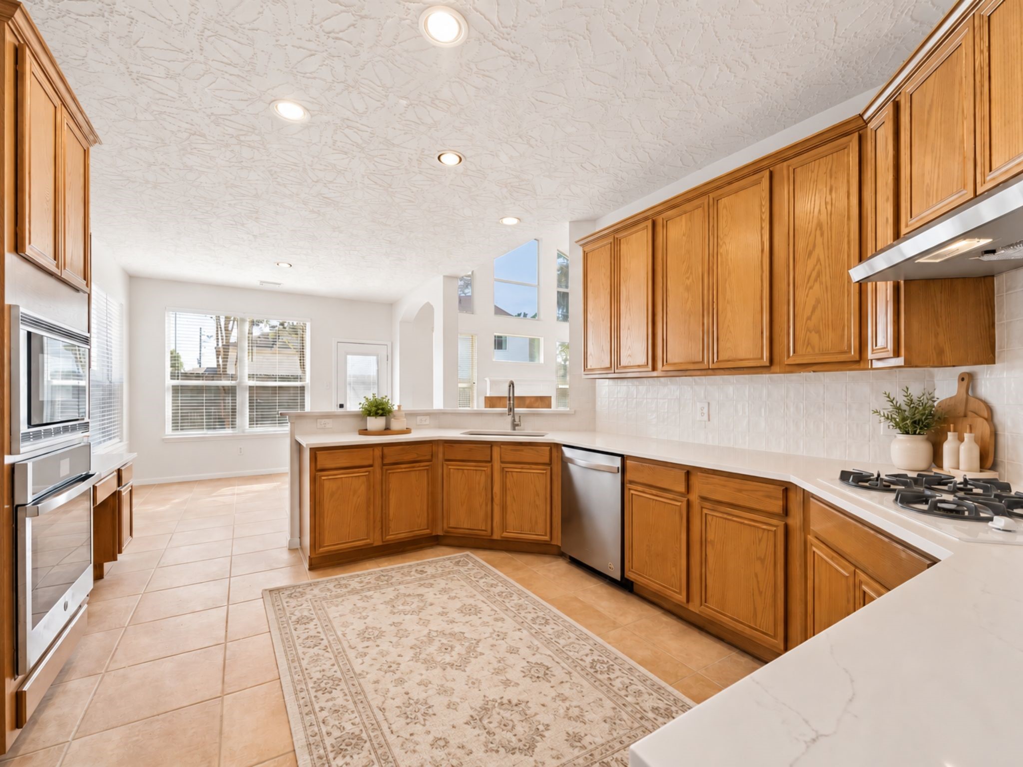 ADDITIONAL KITCHEN STORAGE INCLUDES BUILT-IN APPLIANCES, TALL CABINETRY, AND A CONVENIENT DESK OR PLANNING AREA.