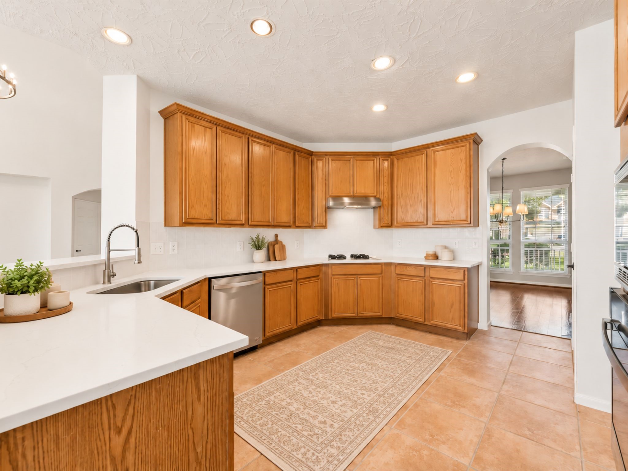 GENEROUS KITCHEN OFFERS EXTENSIVE PREP SPACE, BUILT-IN APPLIANCES, A GAS COOKTOP, AND A LARGE PENINSULA.