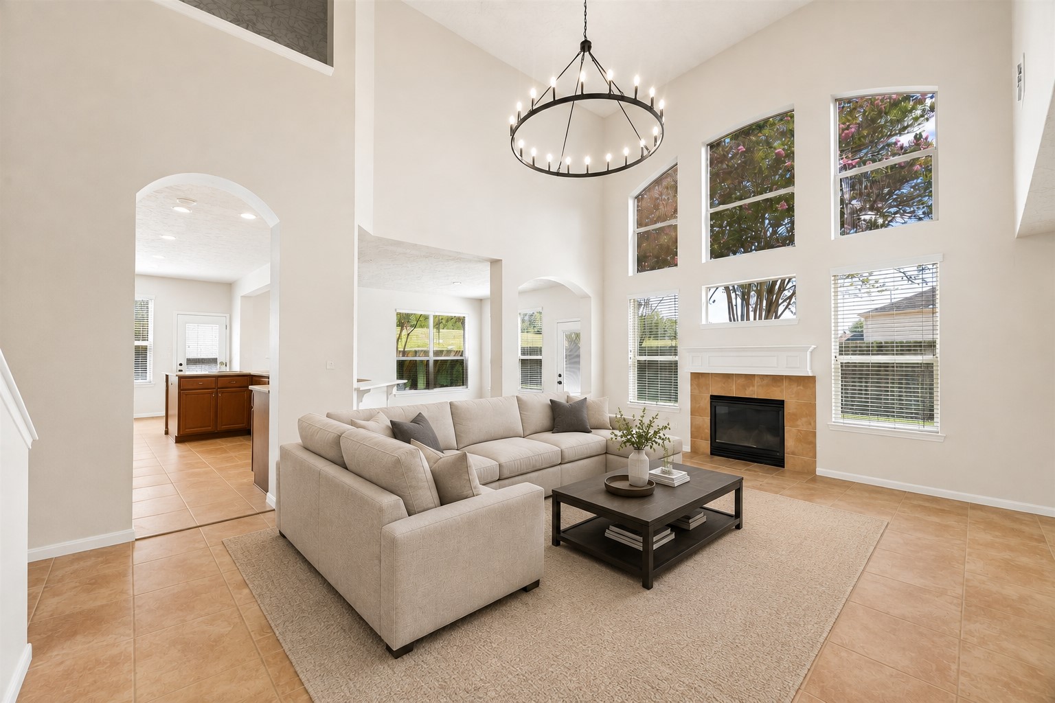 SOARING TWO-STORY LIVING AREA WITH OPEN SIGHTLINES TO THE KITCHEN AND BREAKFAST SPACE. A LARGE STATEMENT CHANDELIER AND ABUNDANT NATURAL LIGHT EMPHASIZE THE IMPRESSIVE SCALE.