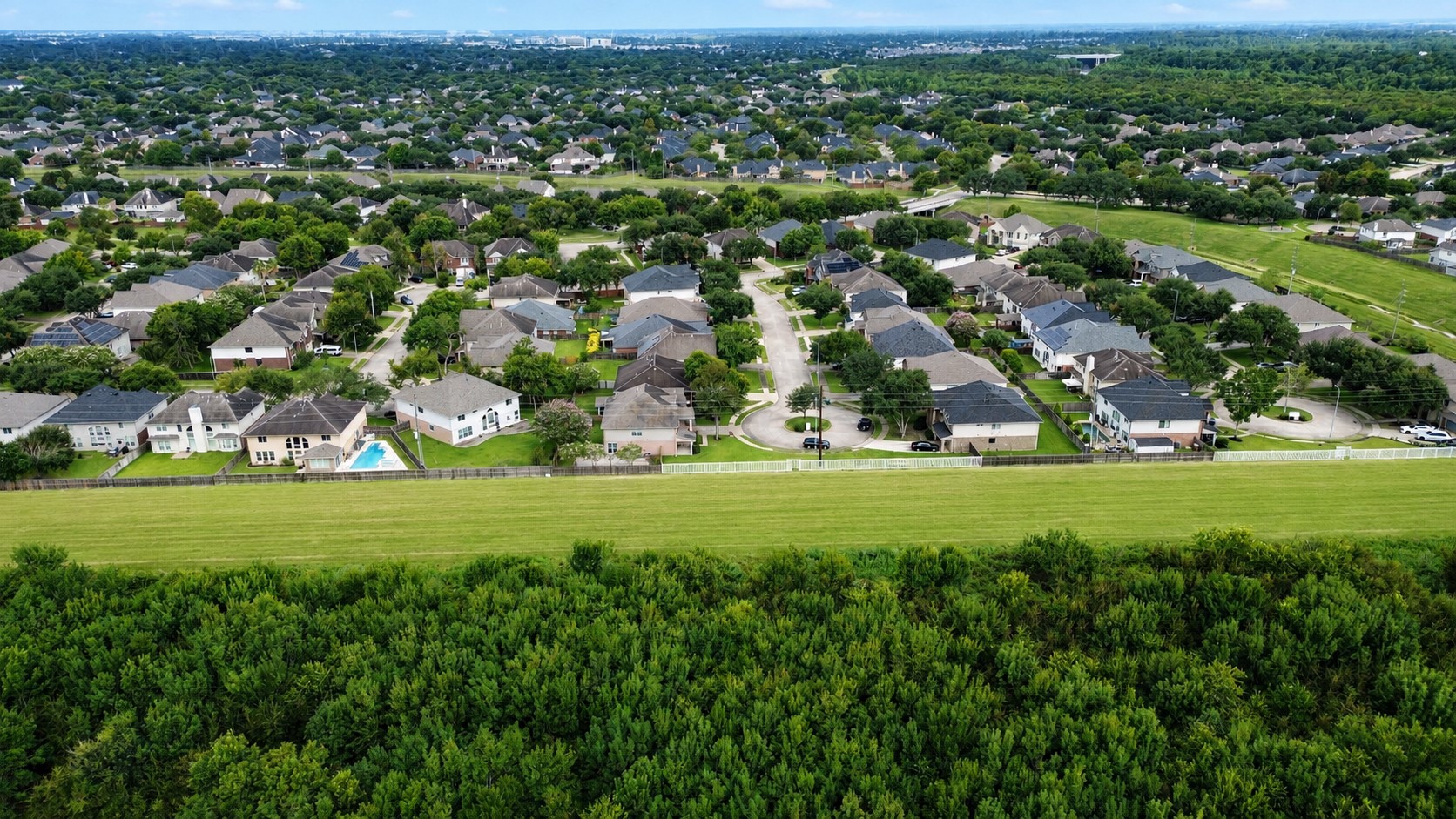 SWEEPING AERIAL VIEW OF GREATWOOD SPRINGFIELD SHOWCASES THE ESTABLISHED NEIGHBORHOOD, TREE-LINED STREETS, AND EXPANSIVE LEVEE GREENSPACE.