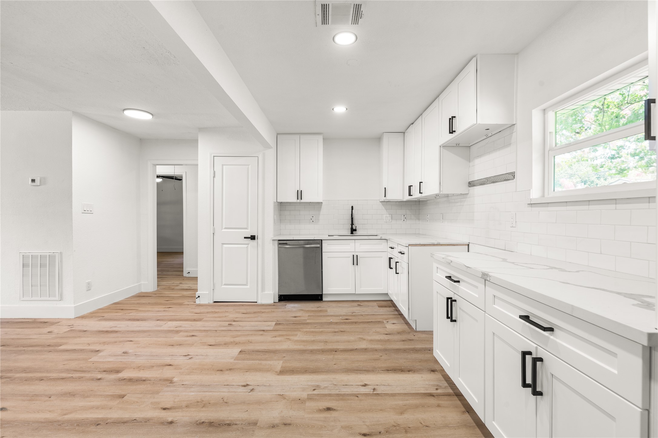 Modern kitchen layout highlighting expansive prep counter space, and a classic subway tile backsplash.