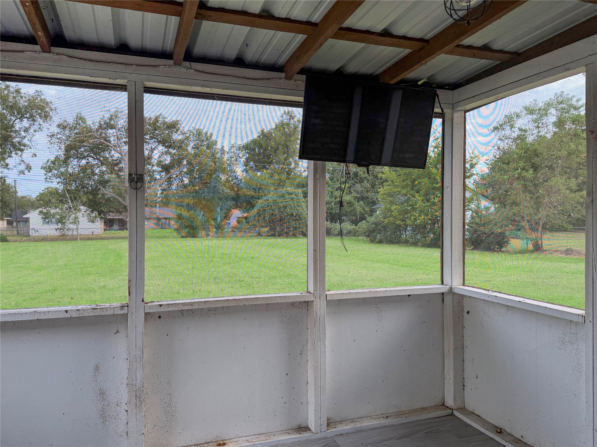 Small screened-in back porch overlooking the spacious backyard, offering a relaxing spot to enjoy the outdoors.