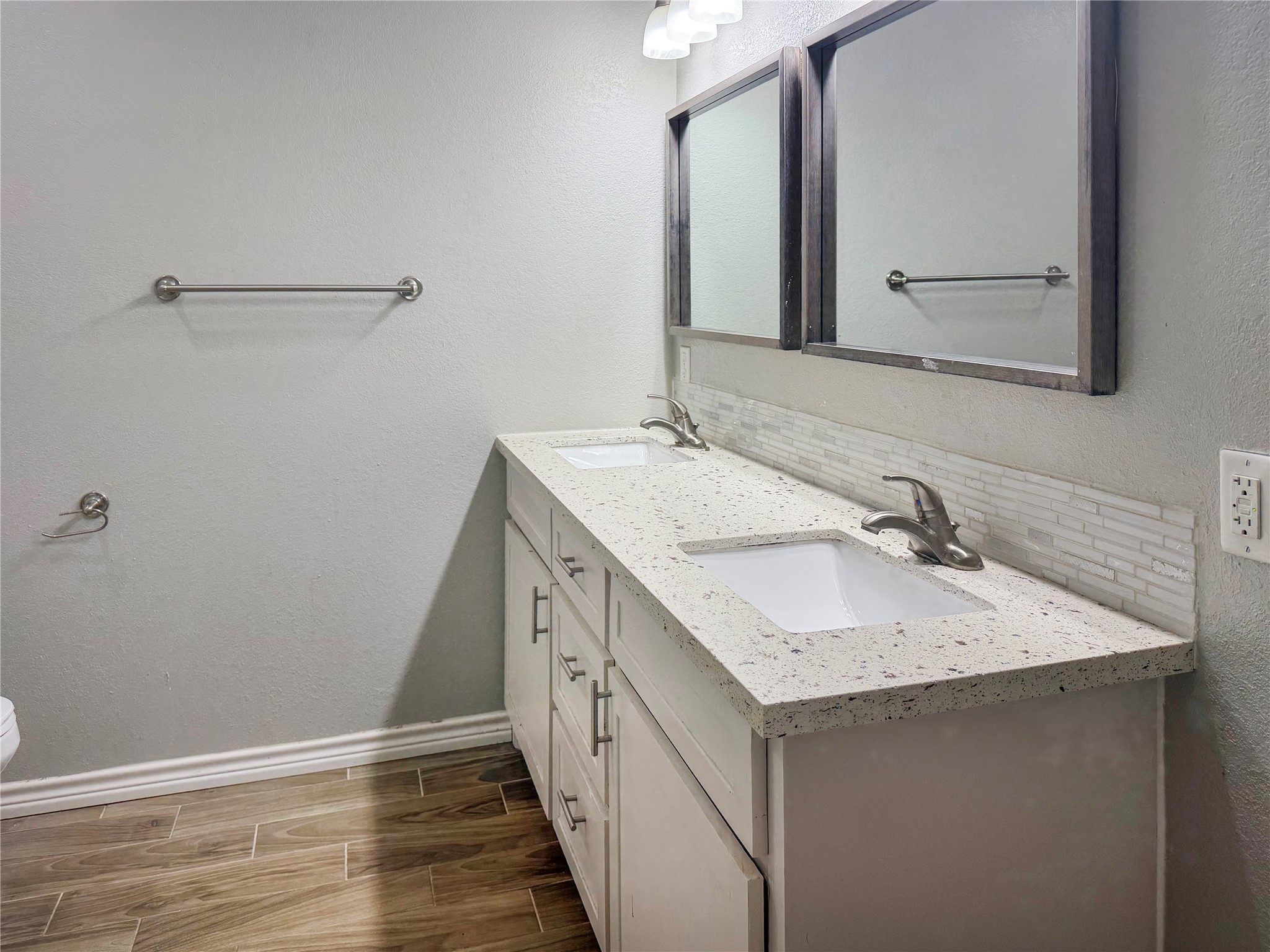 Primary bathroom features a double-sink vanity with white cabinetry, offering convenient counter space and storage for everyday essentials.