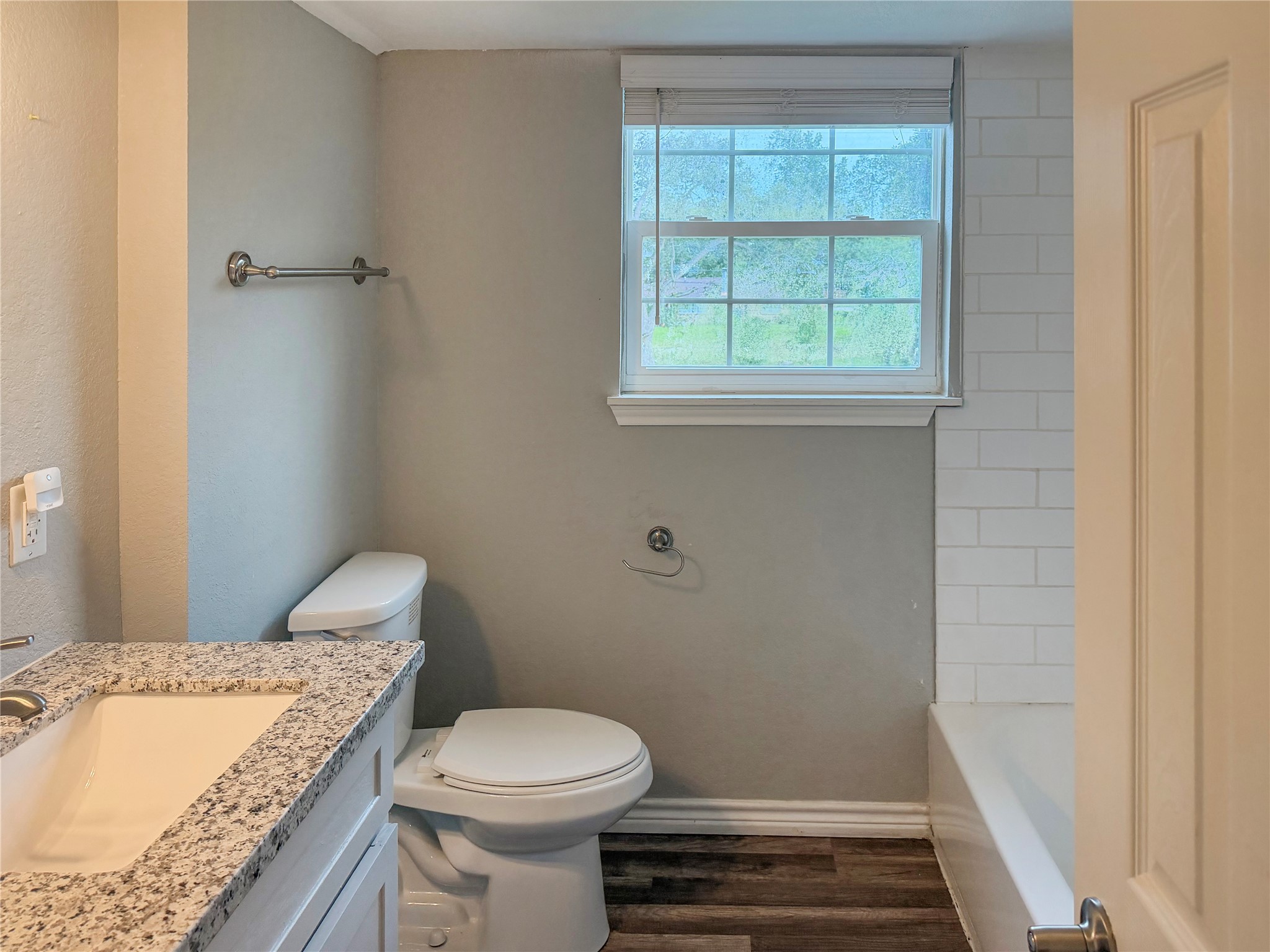 Secondary bathroom features white cabinetry, providing convenient storage and a clean, classic look.