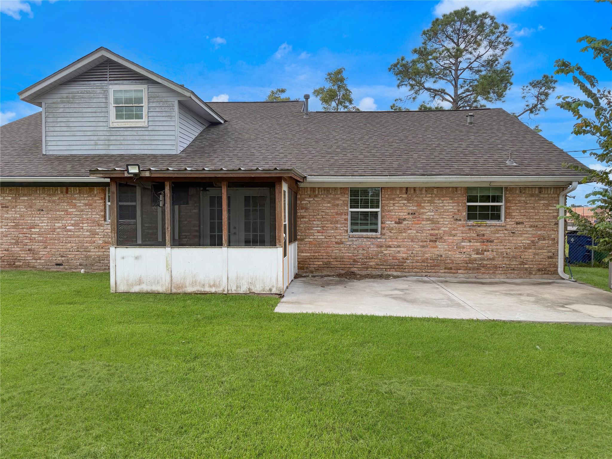 Screened-in back porch provides a comfortable space to enjoy the outdoors, while the adjacent concrete slab offers additional room for grilling, seating, or relaxing.