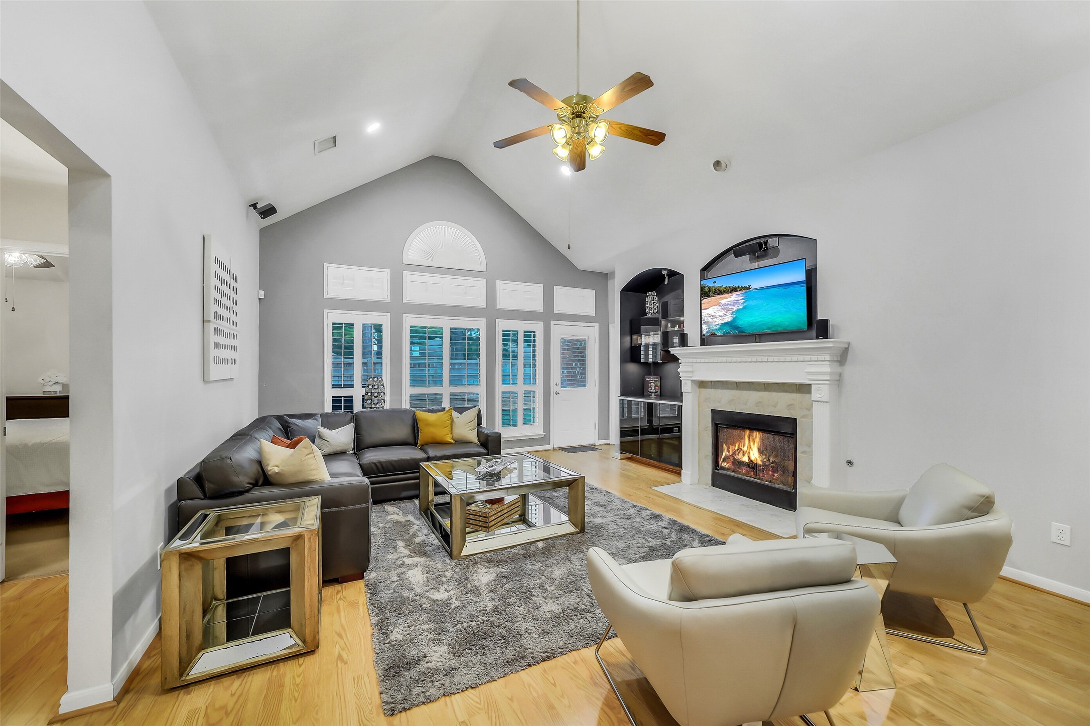 Living room with ceiling fan, recessed lighting, cozy fireplace, and elegant floors.