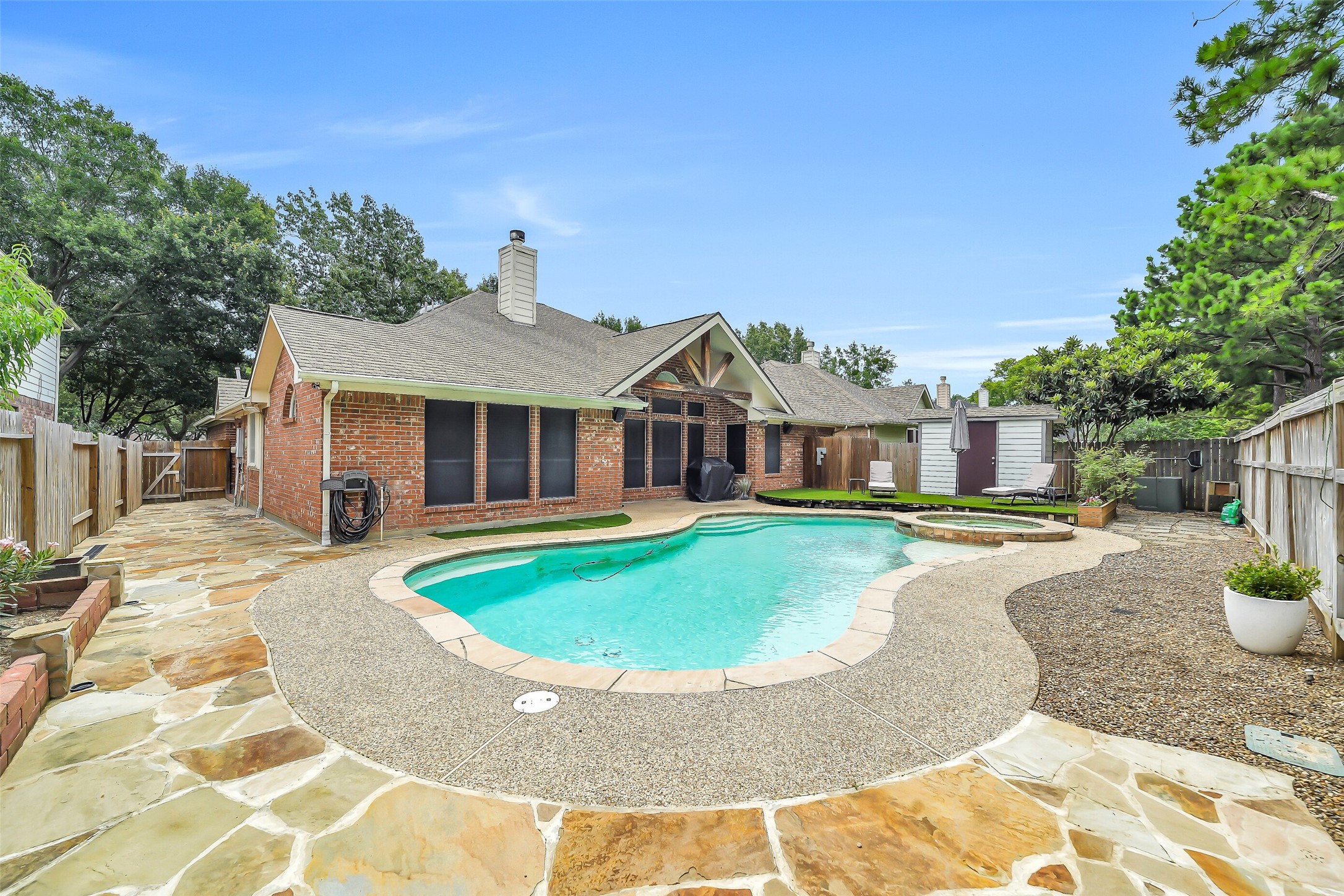 This low-maintenance backyard oasis features a sparkling pool and spa, a spacious deck perfect for entertaining, a covered patio, a handy storage shed, and stunning flagstone accents. This low-maintenance backyard oasis features a sparkling pool and spa, a spacious deck perfect for entertaining, a covered patio, a handy storage shed, and stunning flagstone accents.