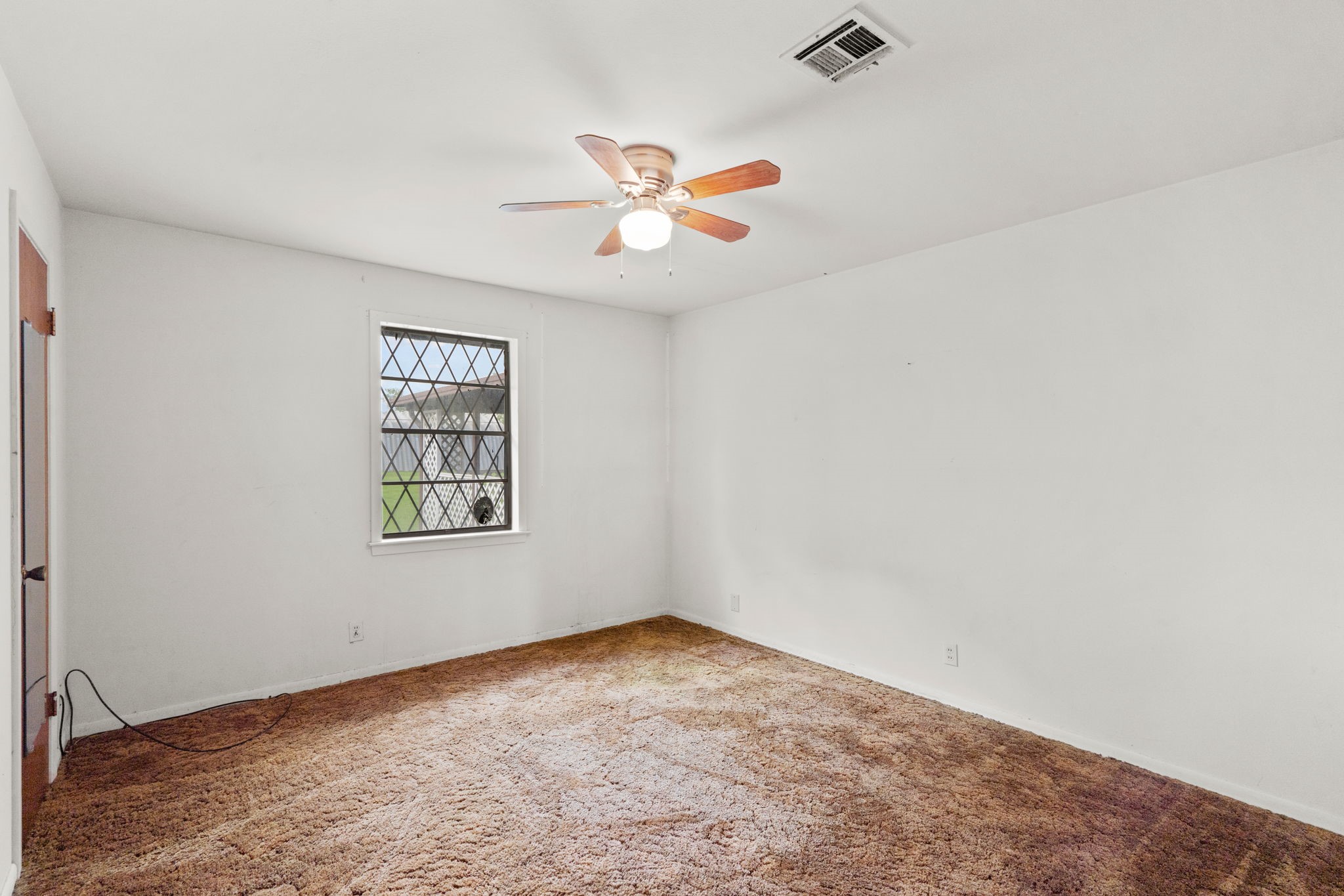 Bedroom with natural light and ceiling fan.