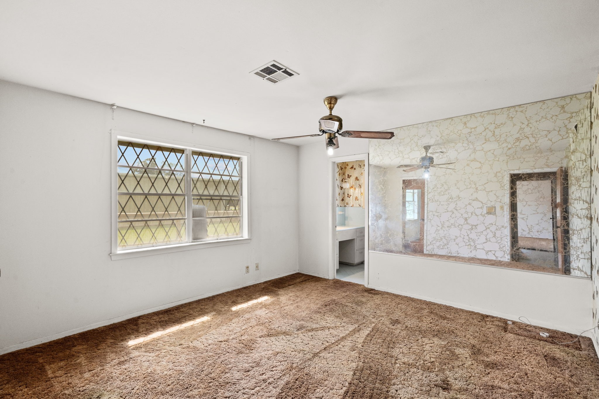Primary bedroom with large window and adjoining bathroom.