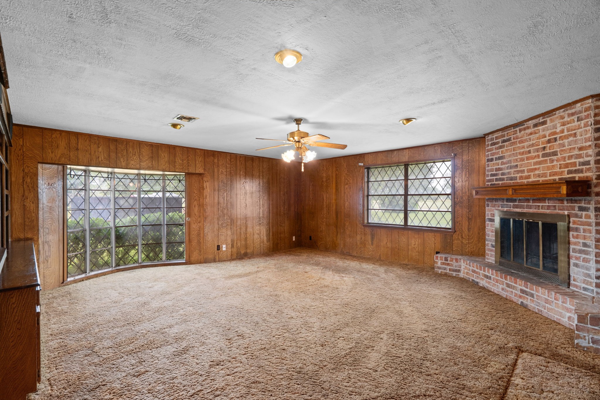Family room with brick fireplace and large windows. Family room with brick fireplace and large windows.