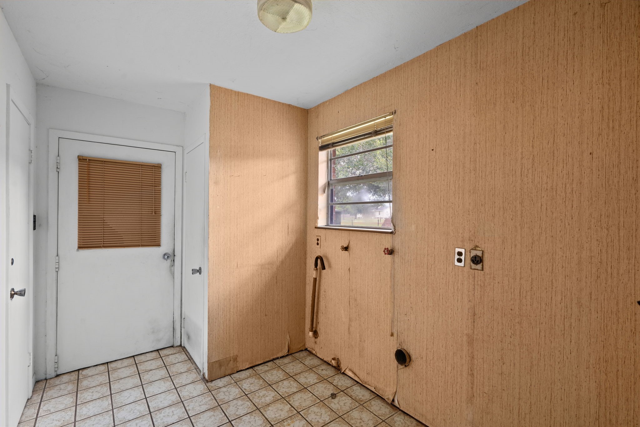 Utility room with washer and dryer connections and exterior access.