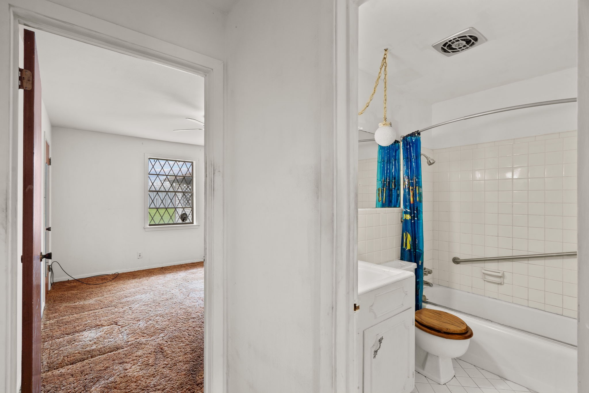 Full bathroom with tub/shower combination and adjacent bedroom access.