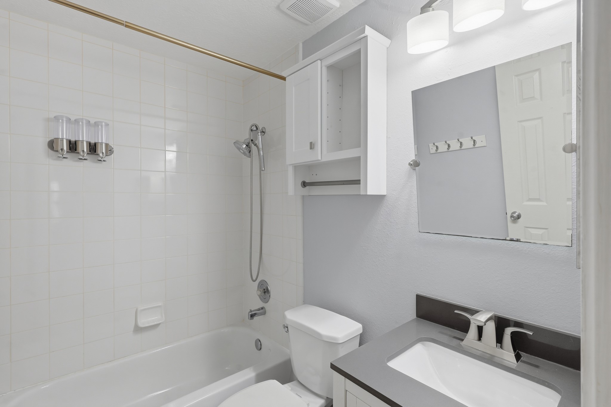 Bright secondary bathroom with clean, neutral finishes and convenient storage.