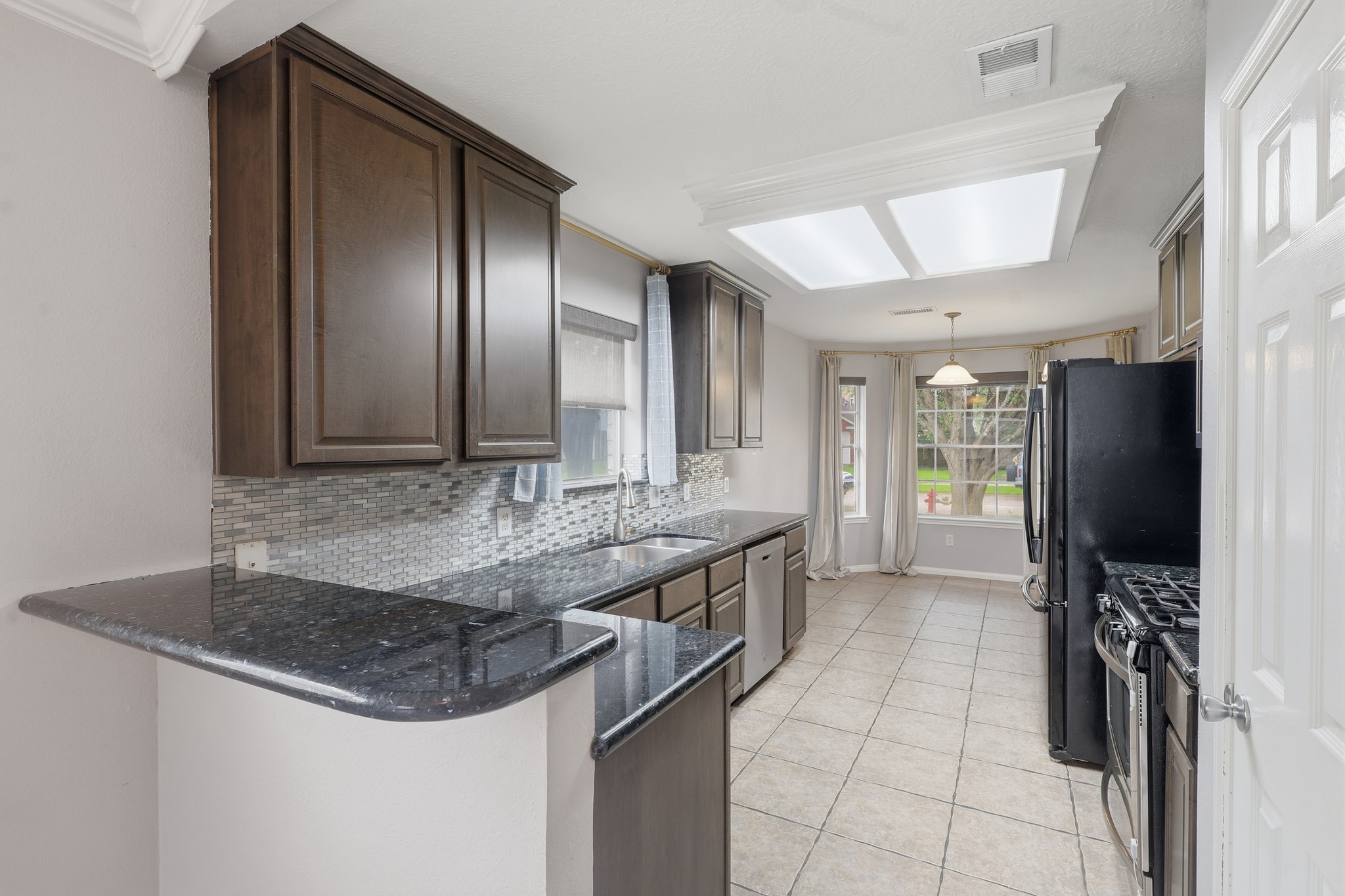Remodeled kitchen with granite countertops, rich cabinetry and generous prep space.