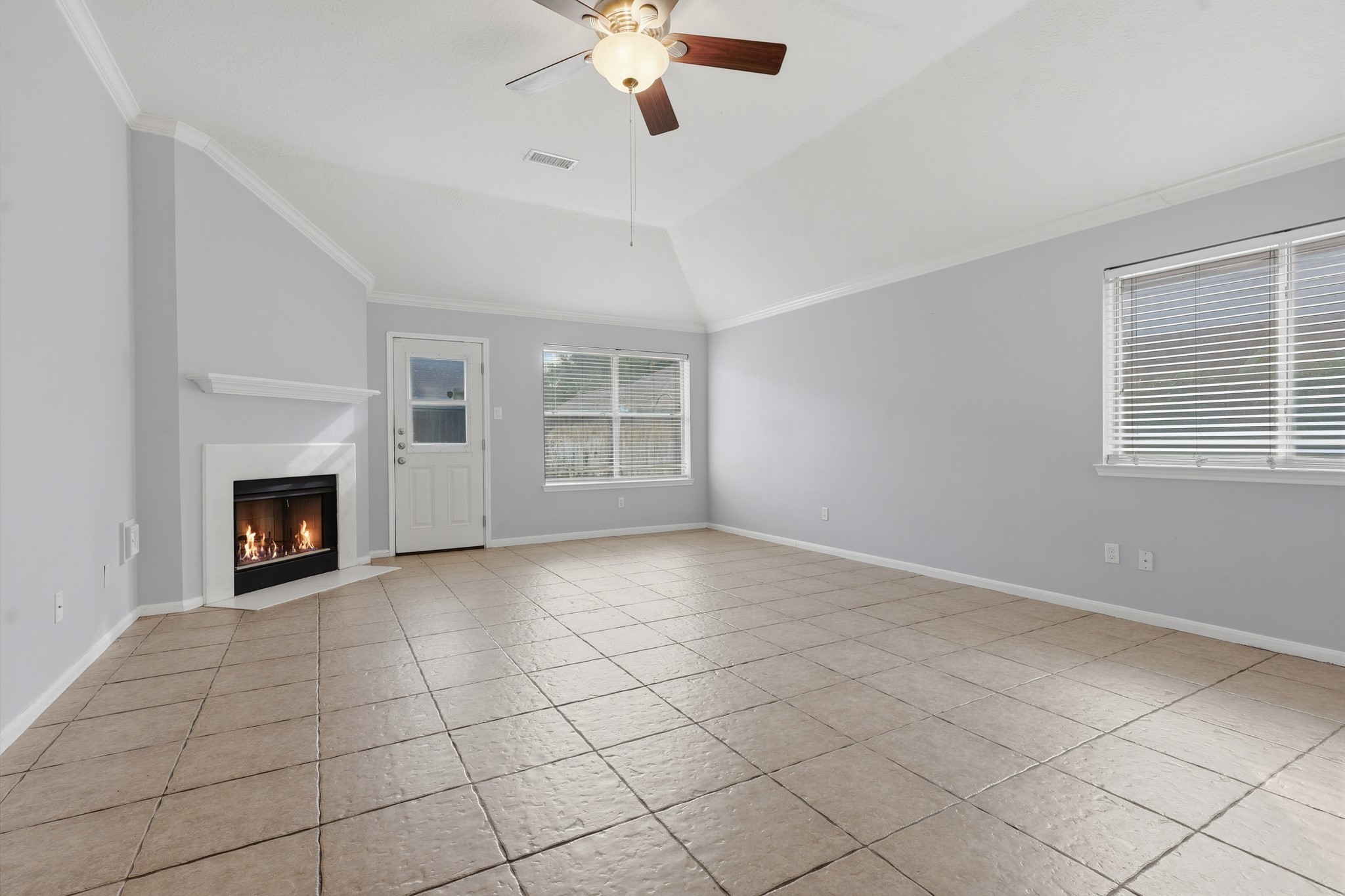 Spacious living area with tile flooring, fireplace and plenty of natural light Spacious living area with tile flooring, fireplace and plenty of natural light