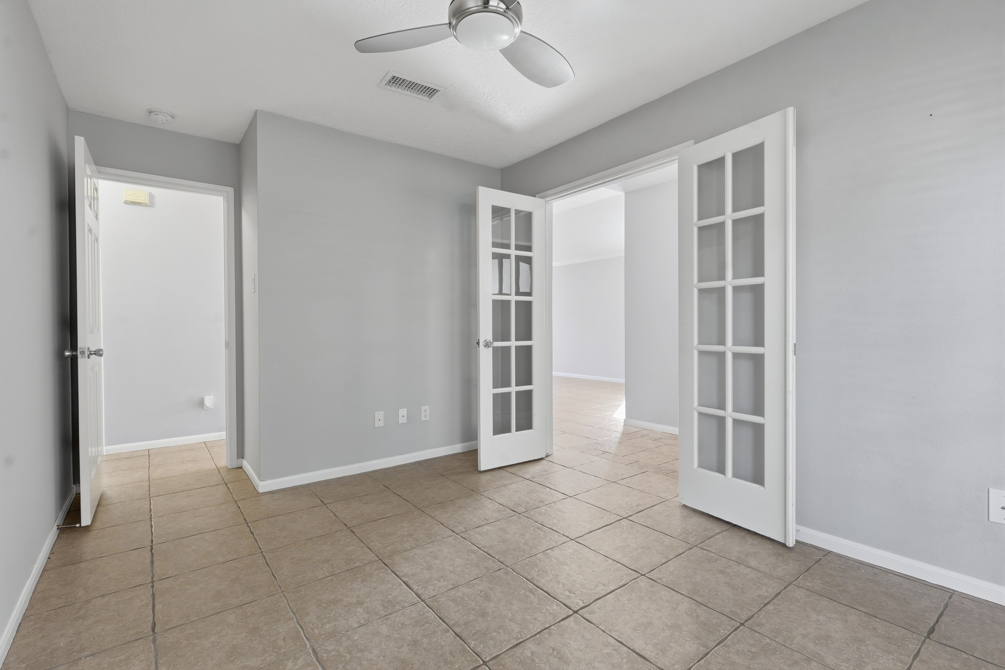 Versatile bedroom with double French doors, ideal for a home office, study or flex space.