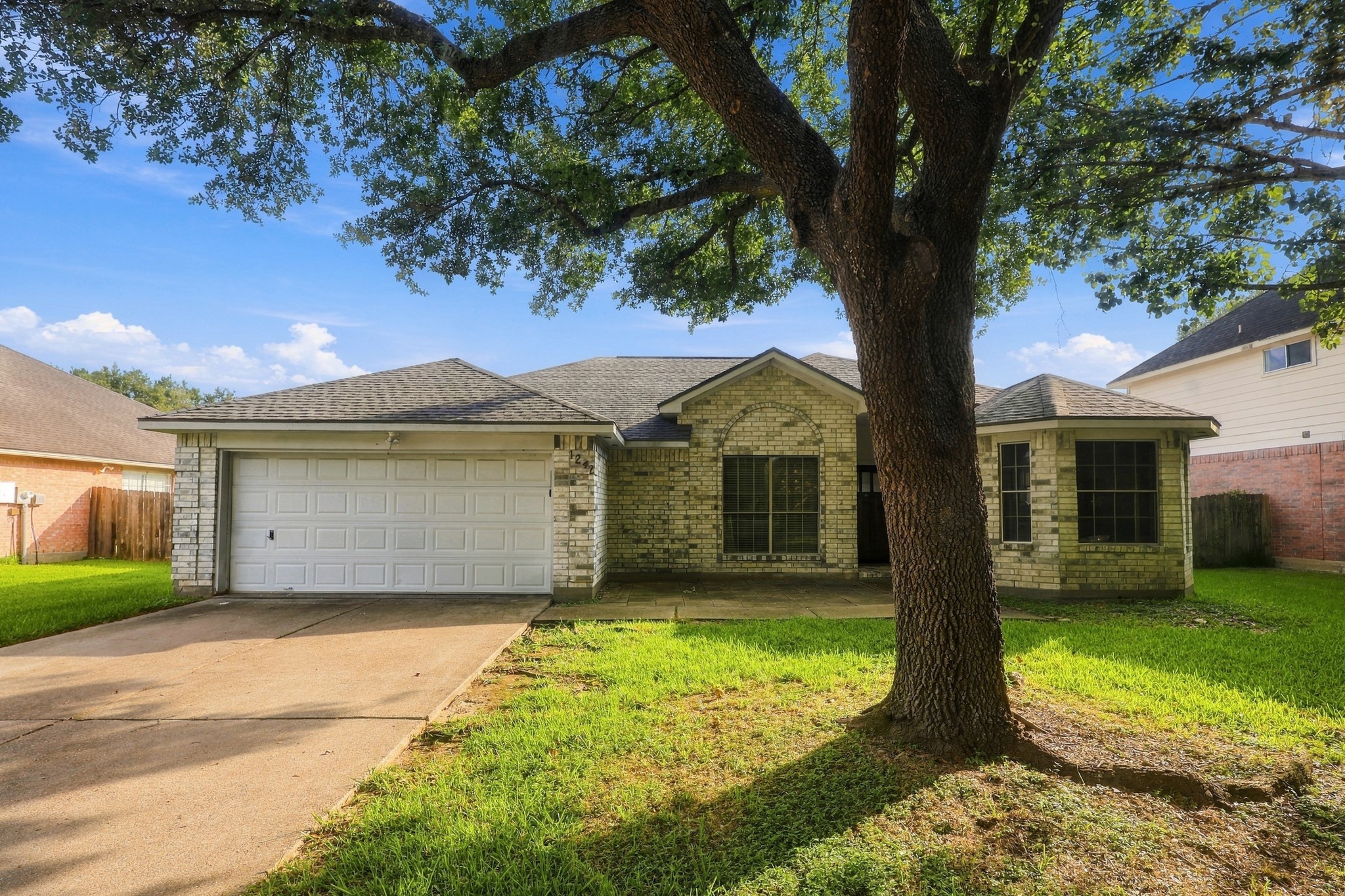 Charming one-story home with mature shade tree and welcoming curb appeal.