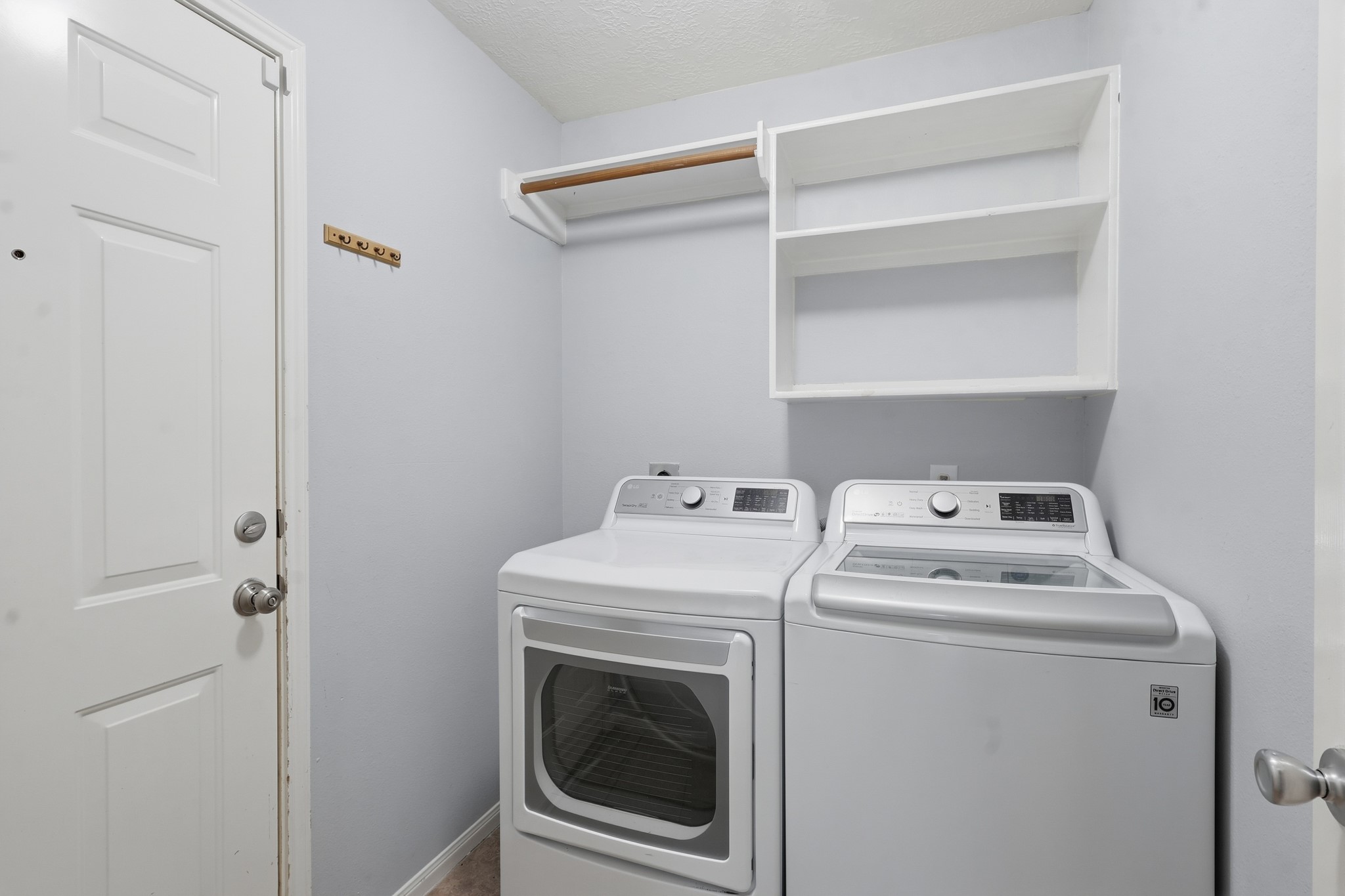 Dedicated laundry room with built-in shelving for added storage and organization.