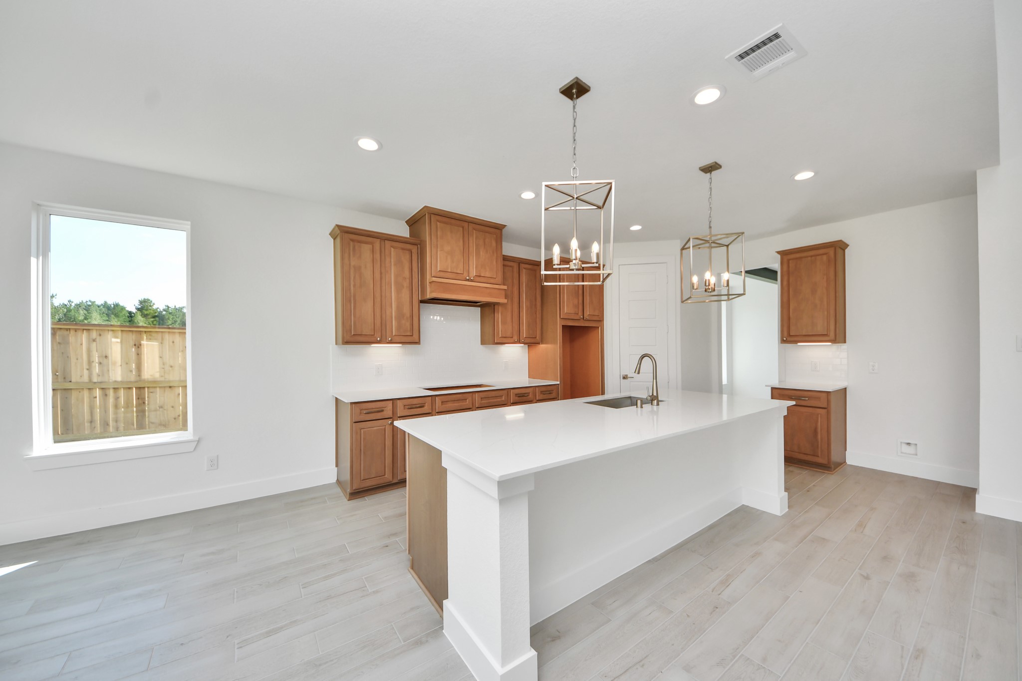 This kitchen is truly a chef's dream! This haven Boasts high ceilings, recessed & pendant lighting, stained wood cabinets, granite countertops, stainless steel appliances, a modern tile backsplash.  All of this overlooks your expansive family room, creating a perfect space for culinary delights and family gatherings.
