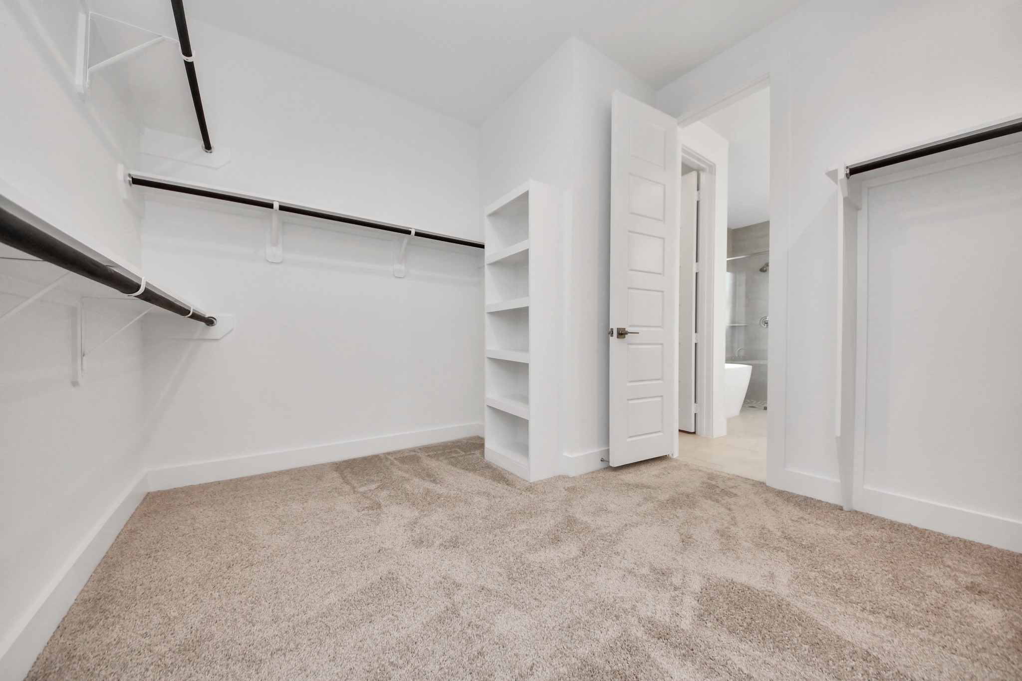 Walk-in closet that epitomizes luxury and practicality. This generously sized space features built-in shelving, offering abundant room for impeccable organization. High ceilings and recessed lighting create a bright and welcoming ambiance.