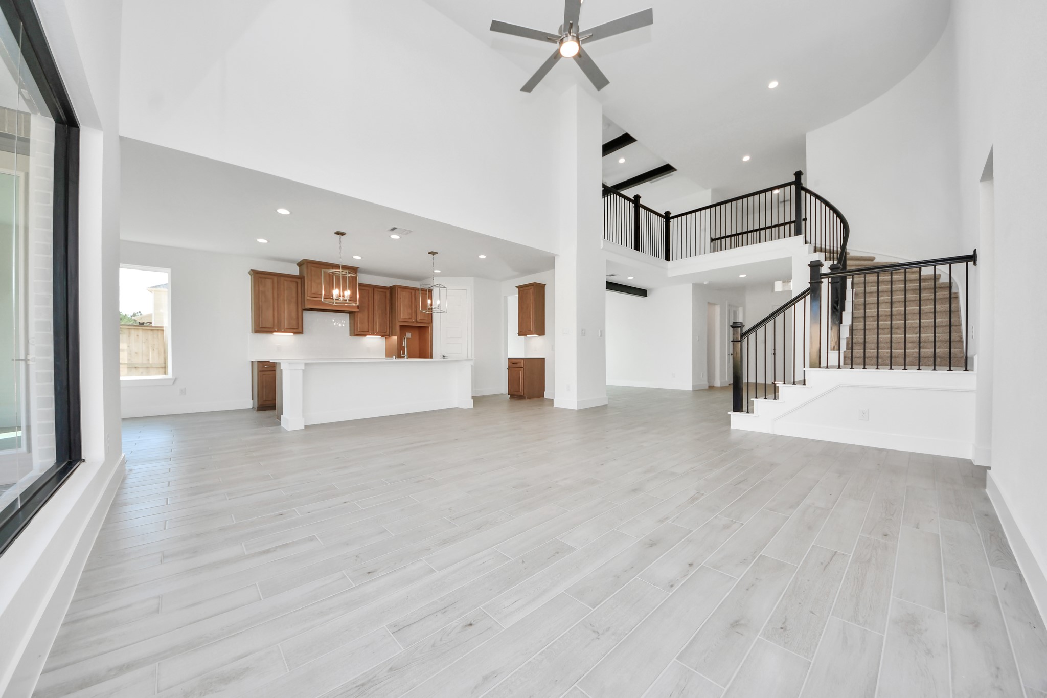 Gather the family and guests together in your lovely living room! Featuring soaring high ceilings, recessed lighting, ceiling fan, custom paint, gorgeous floors, and large windows that provide plenty of natural lighting throughout the day.