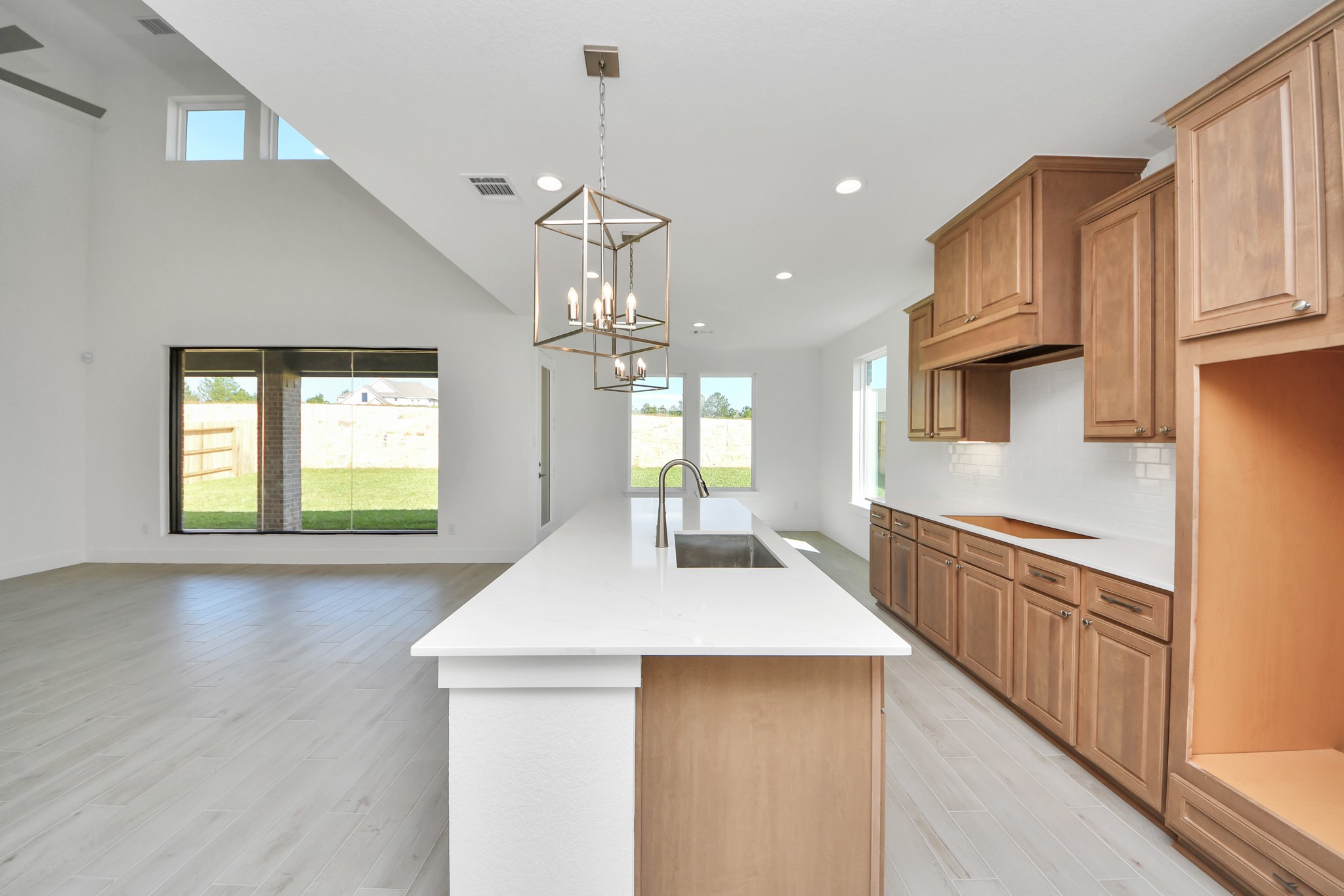 This kitchen is by far any chefs dream! This spacious kitchen features high ceilings, stained wood cabinets, granite countertop, SS appliances, modern tile backsplash, recessed lighting, extended counter space, granite kitchen island with double sink, and space for breakfast bar, and a walk-in pantry all overlooking your huge family room.