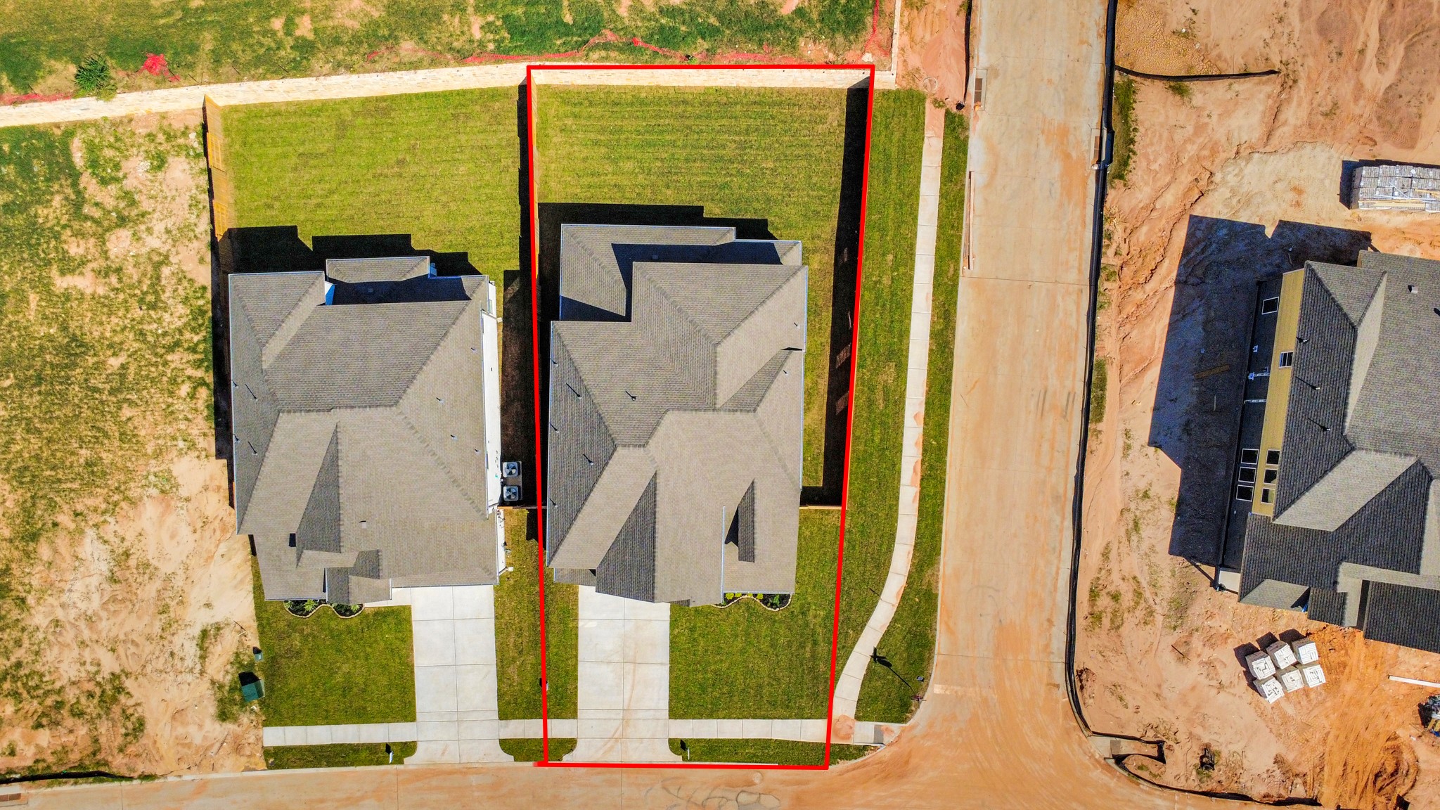 An aerial view of a spacious subdivision lot, highlighting a well-maintained yard and a fully fenced perimeter, offering both privacy and expansive outdoor space.