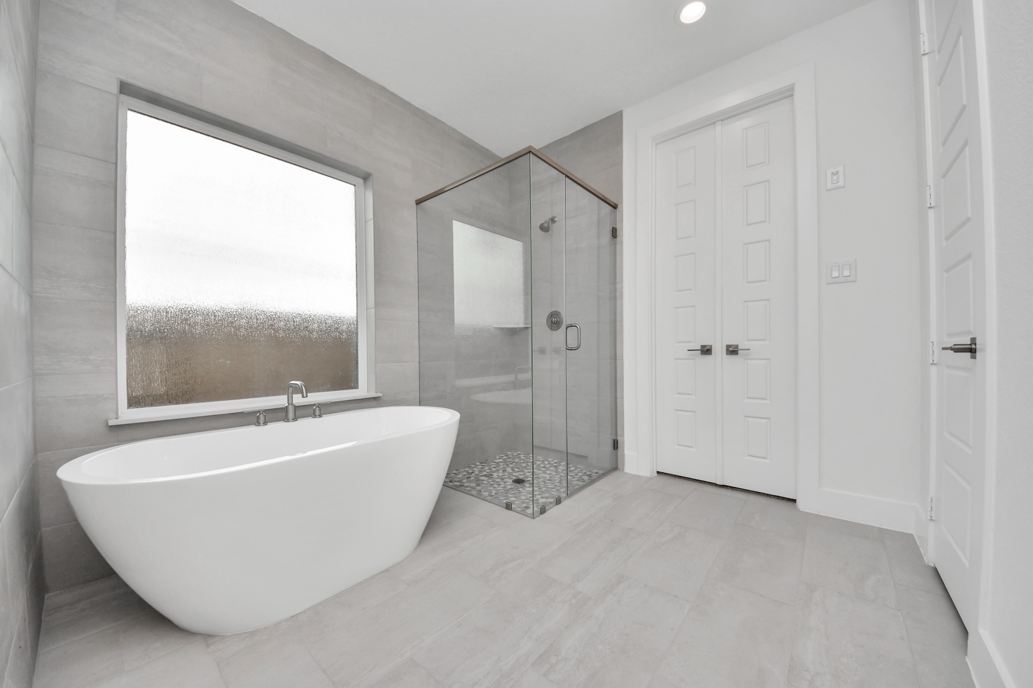Indulge in a spa-like retreat within the confines of this primary bathroom. Delight in a spacious walk-in shower enveloped in stylish tile surround, unwind in a separate garden tub adorned with custom detailing.