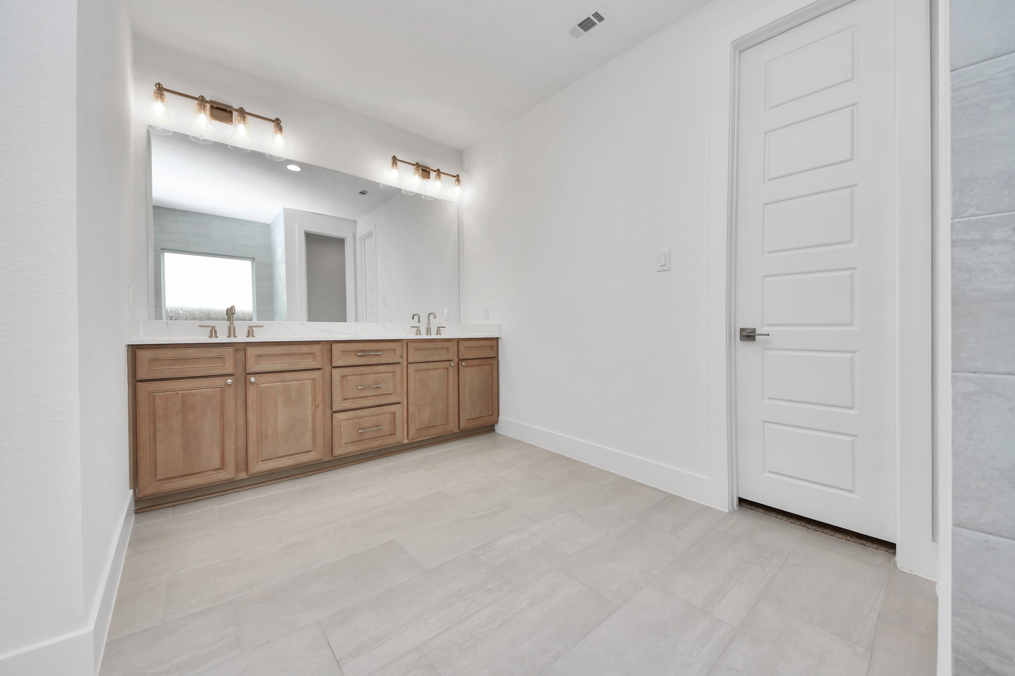 Elevate your daily routine at the elegant vanity, now equipped with double sinks, light countertops, modern hardware, and beautiful vanity lights.